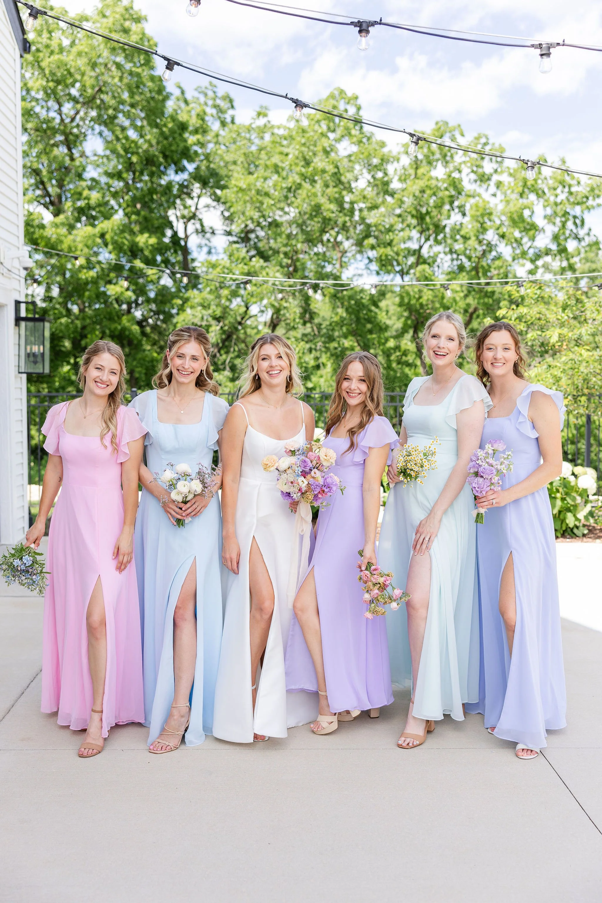 Bride and bridesmaids holding pastel wedding bouquets designed by 1209 Creative at The Eloise in Madison Wisconsin, styled with light airy editorial florals