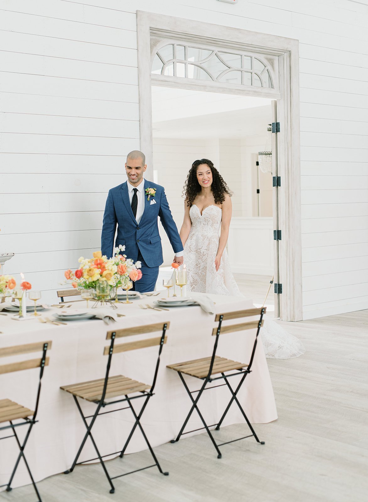 Bride and groom walking into their wedding reception at Providence Vineyard in Hebron Illinois with florals designed by 1209 Creative, showcasing an editorial vineyard wedding aesthetic