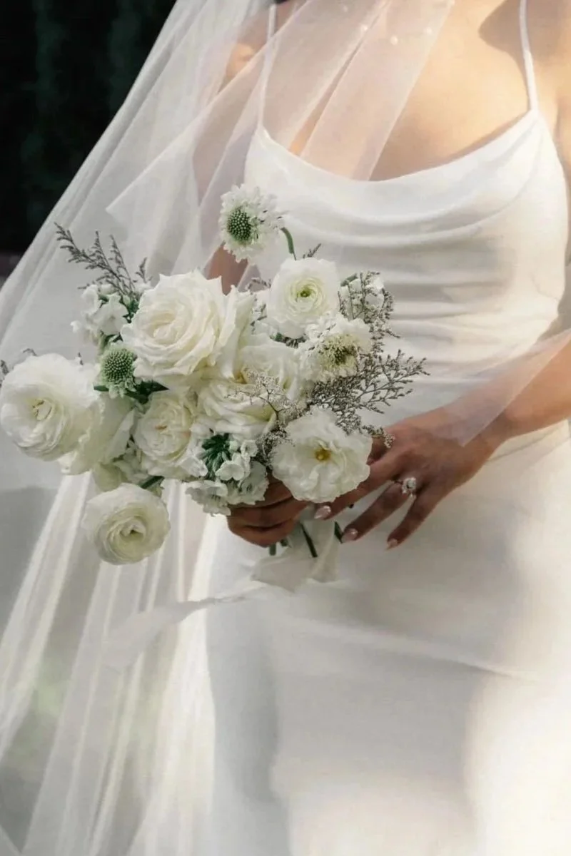 White bridal bouquet with roses and ranunculus for a Scottsdale, Arizona wedding, designed by 1209 Creative.