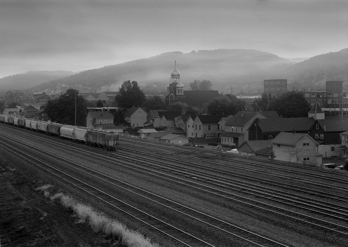 The sleepy Borough of Franklin wakes up in a low fog alongside former Woodvale Yard on the PRR mainline about 275 miles West of Philadelphia's Broad Street Station. Like many local communities Franklin has a prominent church, St john the Baptist that stands dominant along the nearby mountain ridge.