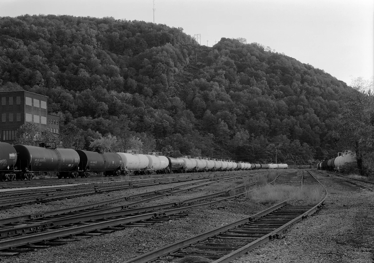 Stored tank cars awaiting reconditioning. The weedy yard and empty tracks of the C&BL interchange yard speak of the impending shut down of Railcar America facility which happened in 2008.