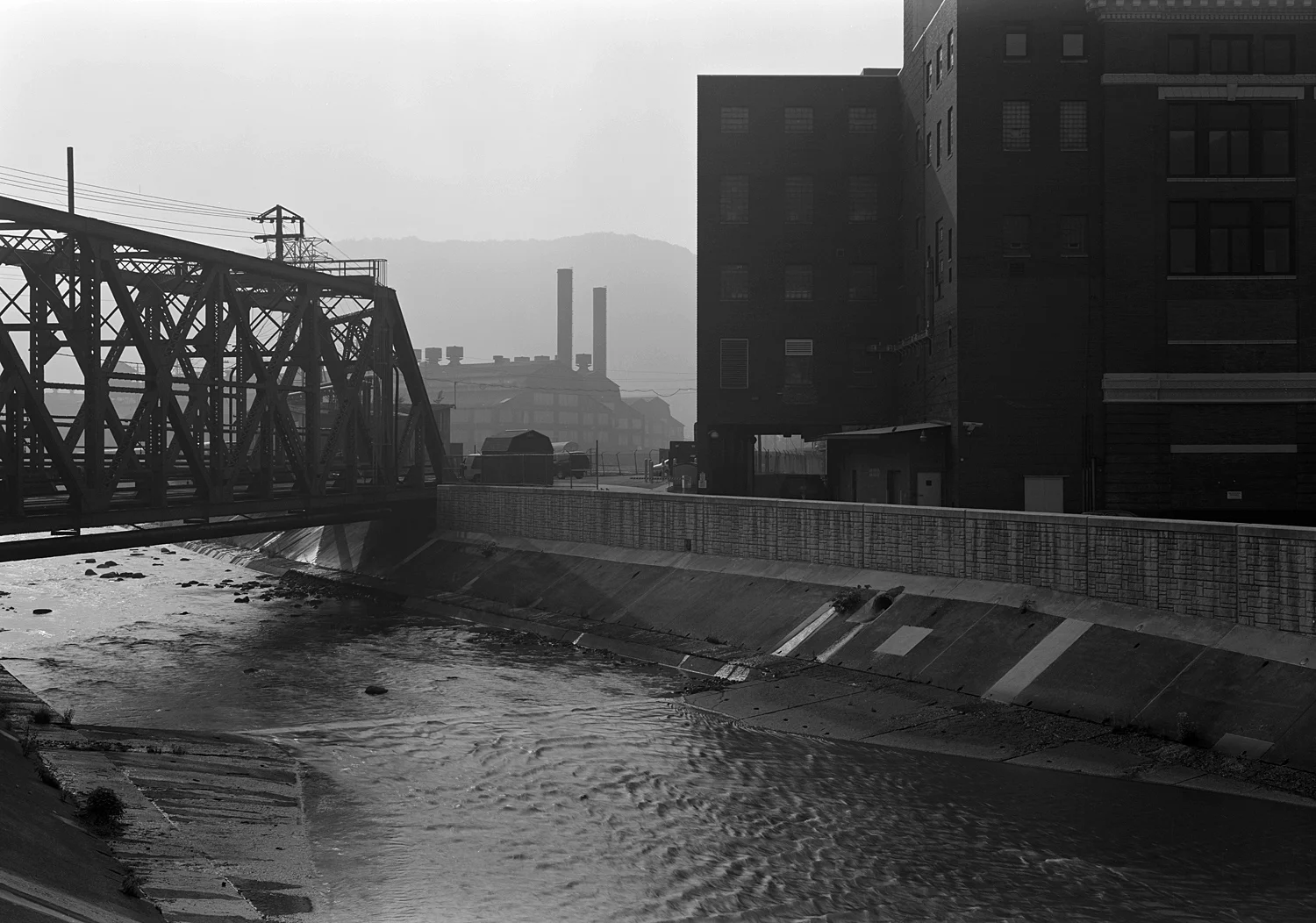 Leaving the Gautier Works complex behind the C&BL crosses the Conemaugh River on a impressive through truss span, and ducks under the PRR mainline just East of the Johnstown train station.