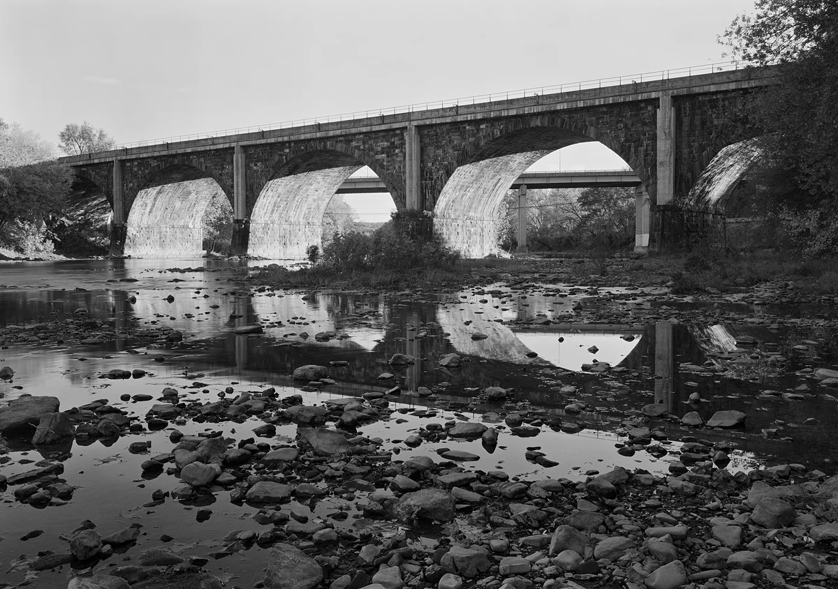 Upstream side of Bridge 147 on the Former PRR Middle Division, completed in 1906. Note the center pier (center of the image), expanded to emphasize the center of the bridge, a nod to traditional stone arch bridge building aesthetics. To the immediate right the railroad crosses Croghan Pike, Route 522 and enters town to the North of the sprawling interchange complex of the East broad Top Railroad.