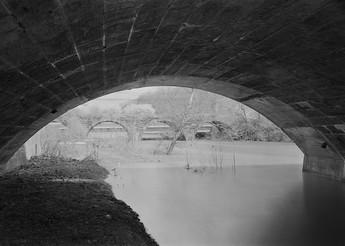 Entering from the east the relocated mainline of the late 1890s runs along the former Public Works Canal alignment. Here at the mouth of Standing Stone Creek we are standing below the "new" bridge looking north toward the remains of the original alignment and stone arch bridge that runs parallel to Penn Street.