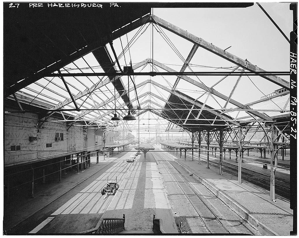 View from photographer Harlen Hambright, taken during the 1981 HAER survey. Survey caption reads "View, looking north (railroad west) under shed from concourse, showing exposed truss after shed roofing was removed." Collection of the Historic American Engineering Record, National Park Service.