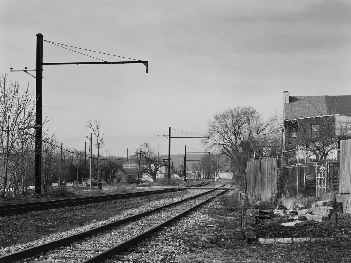 View looking west from the Columbia Branch near the Mill Street crossing. This is the original Philadelphia & Columbia alignment and is operated by NS to access Lancaster area industries and Dillerville Yard, the center of freight operations in the area. Note the steep descent of the branch, compared to the Low Grade visible to the left, which utilized heavier catenary supports on account of it supporting high voltage transmission lines to Royalton. In typical PRR fashion the Columbia branch was maintained to high standards including the use of catenary to provide a relief route in the event there was wreck on neighboring lines.
