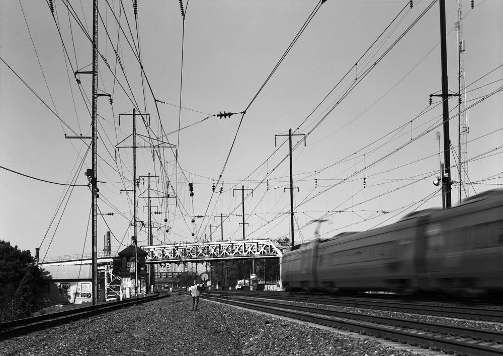 The PRR electrified network still serves the modern needs of Amtrak, providing propulsion for Acela, regional and local passenger rail service through out the Northeast. At Shore, on the Northeast Corridor a southbound passes as another northbound region approaches. Note the catenary above the void in front of the camera, this is where the line to Delair diverges and used to have multiple tracks, all electrified into Pavonia Yard in Camden.