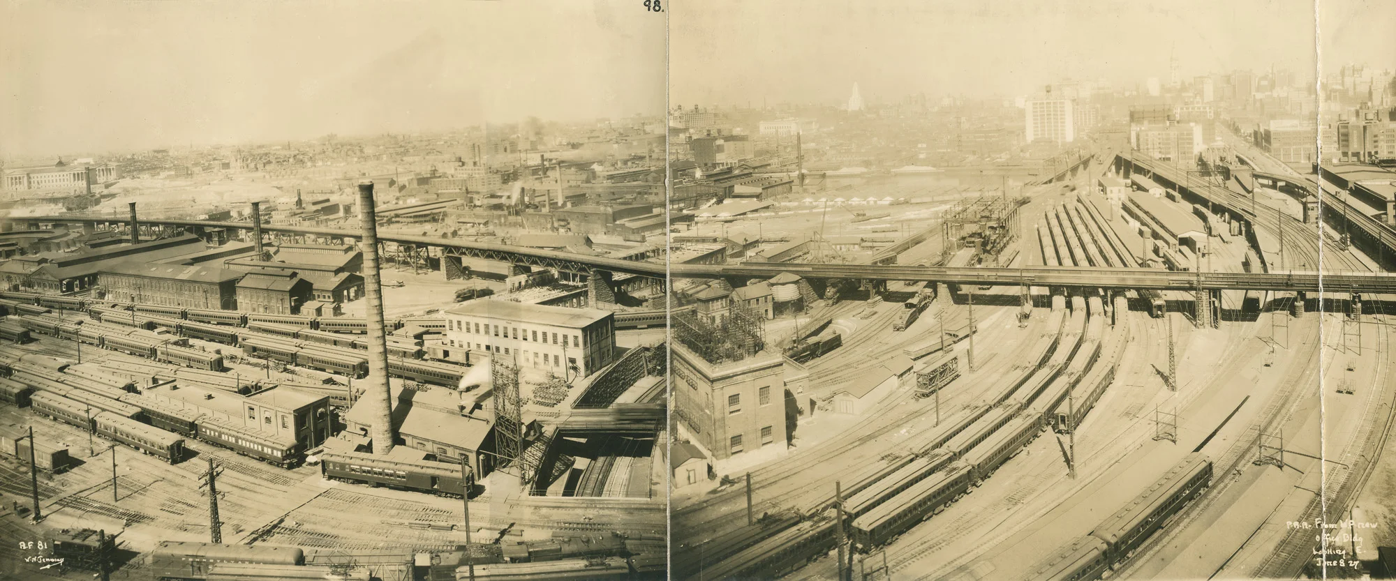 Beginning in the mid 1920's the Pennsylvnia Railroad sought to eliminate Broad Street Station, replacing it with two new stations and modifying another existing station to provide three primary facilities serving commuter, east-west and north- south passenger service. 30th Street Station would be built on the west bank of the Schuylkill River, necessitating extensive changes to the rail yards pictured here, including the elimination of the railroad shops and West Philadelphia Station in the bottom right corner. This image is looking east from the office tower built by the PRR on 32nd Street, known today as the University Crossings Apartment Complex. Photograph by William N. Jennings, courtesy of the Charlie Horan Collection. 