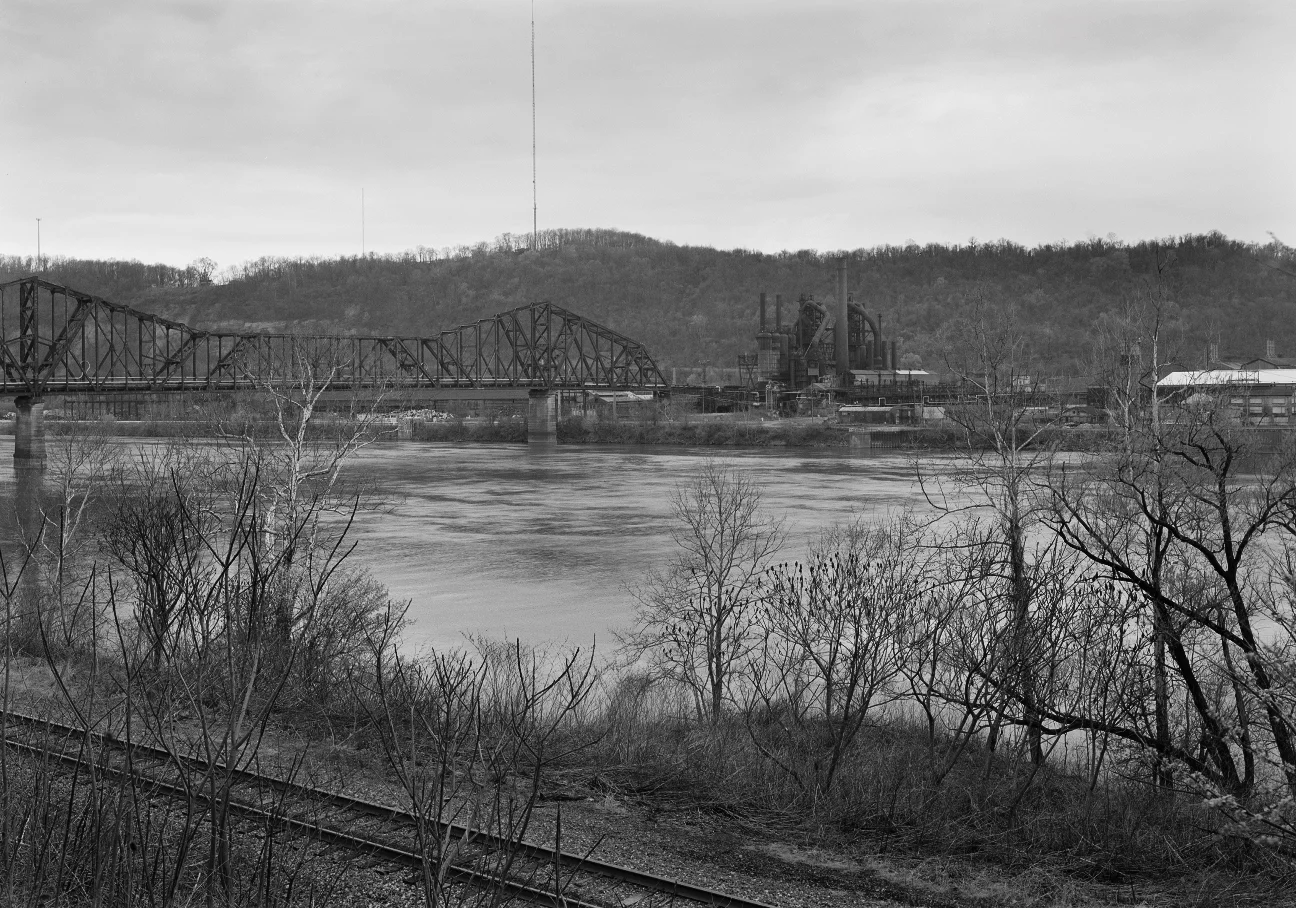 The remaining blast furnaces of the Wheeling-Pitt North Plant was one of many industrial landmarks along the Ohio River, complete with a large cantilevered Baltimore truss bridge that linked the North plant with mills on the West Virginia side including the Coke Works in Follansbee. Tracks in the foreground are the Wheeling secondary track, on the Ohio side the PRR's Panhandle Divison Main Line and River branch flanked the former LaBelle furnace converging in Steubenville to the (railroad) east.
