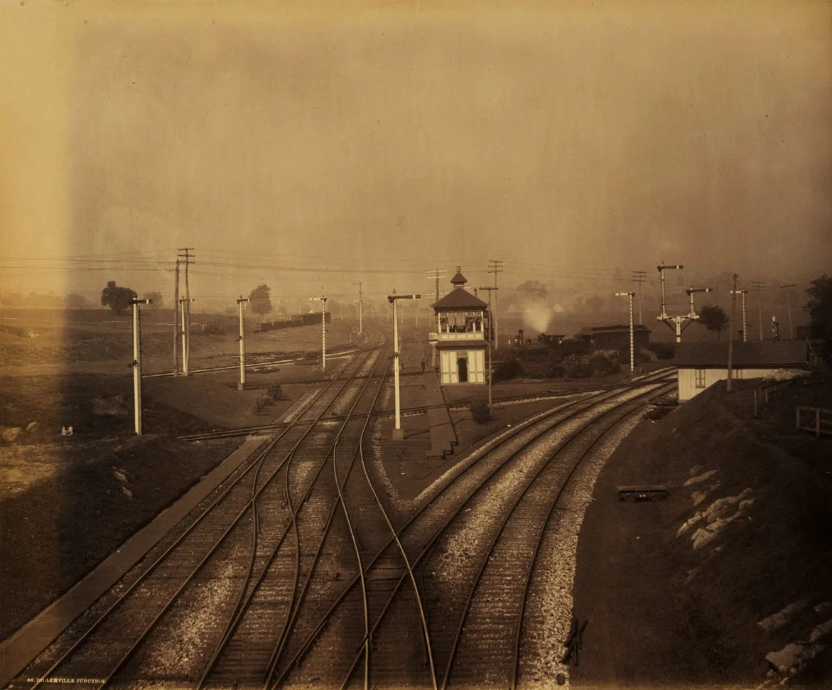Dillerville Junction was a complex interlocking controlling access to several important lines on the PRR in the northwestern corner of Lancaster. This remarkable view looking railroad west from the Lancaster Cut-Off depicts the new line veering off to the right connecting with the H&L line to Harrisburg. The old alignment of the H&L into Dillerville and Lancaster still exists and is where Rau's photographic train is sitting behind the interlocking tower. Straight ahead is the connection to the Columbia Branch while the tracks that fan off to the left from that line in the distance are the original alignment and connection to the Old Main to the Queen Street station. The last line of note through the junction is the single track passing left to right in front of the tower crossing all of the PRR tracks at grade, this was the Reading Company's Lancaster Branch, part of its Reading & Columbia Division which terminated at the foot of North Prince Street. The meticulous landscaping, track and ballast work reflect a railroad that took great pride in their physical plant. Image circa 1888 by William H. Rau, Collection of American Premier Underwriters, Inc. 