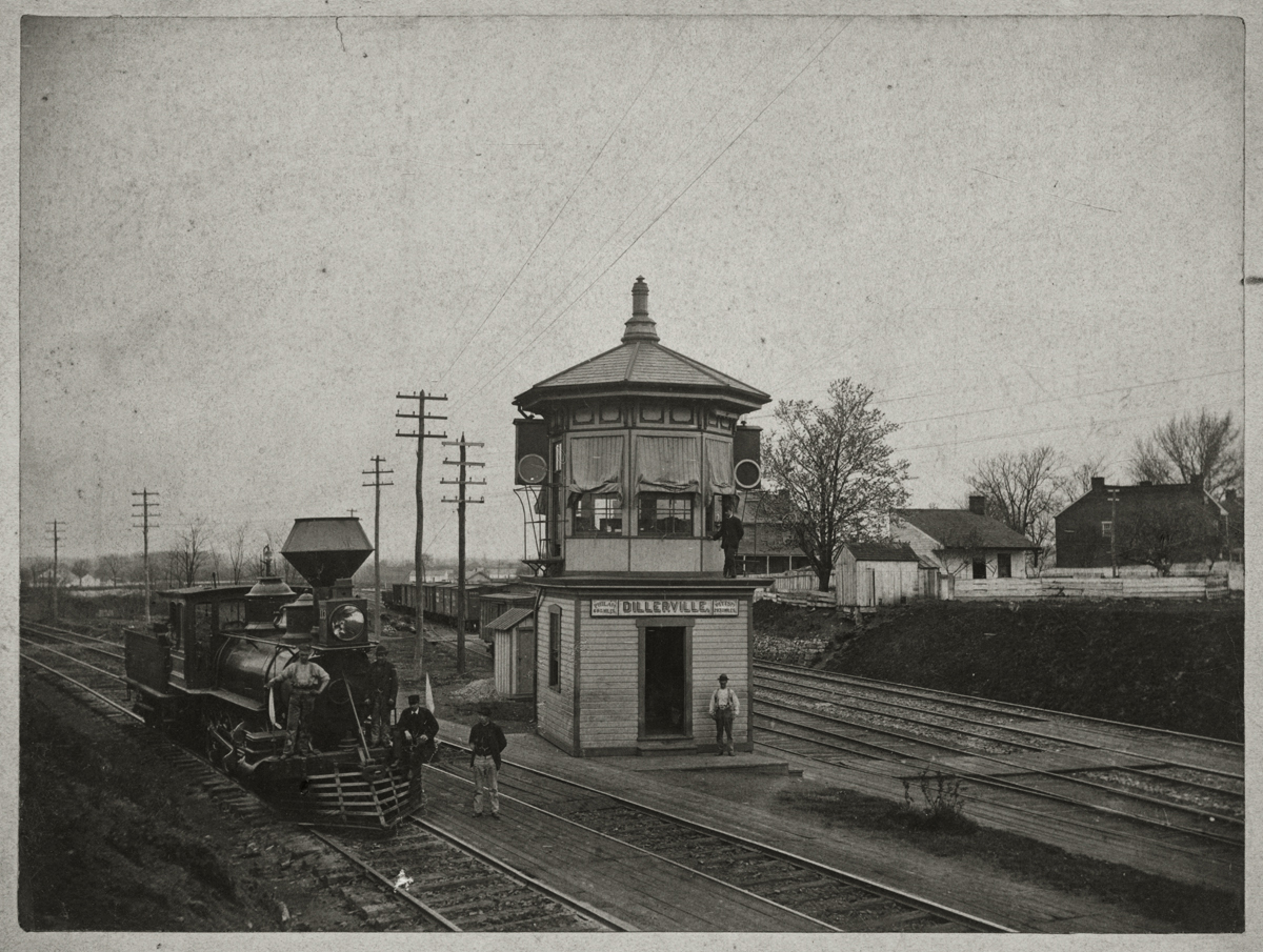 This view looks west depicting the first tower at Dillerville around 1880. To the left is the Columbia Branch of the former P&C and to the right is the former H&L to Harrisburg. Note the sign on this early wood frame octagonal switch tower which proclaims an exact distance of 69 and 30/100 miles to Philadelphia and 283 and 70/100 miles to Pittsburgh. Another noteworthy detail is the early signals utilized to govern traffic at the junction. As evident from Rau's photo in 1888 this junction would be greatly reconfigured with the addition of the Lancaster Cut-off. Photographer unknown, image courtesy of LancasterHistory.org, Lancaster, Pennsylvania.
