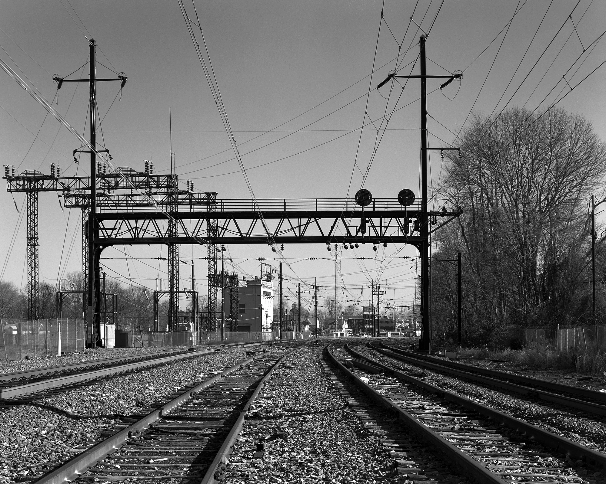 View looking east at the western limits of the Paoli interlocking plant. Number 2 and 3 track mains (center tracks) are basically stub end sidings here used occasionaly for track and maintenance equipment. The surviving infrastructure of the electrification reflects various generations of expansion including the massive singnal bridge, tubular trolley poles and the sub-station. This would have been some of the western most electrified trackage until the 1938 expansion to Harrisburg. Note: This photograph was taken with Amtrak permission under watchman protection, the author does not condone any type of trespassing on railroad or private property. 