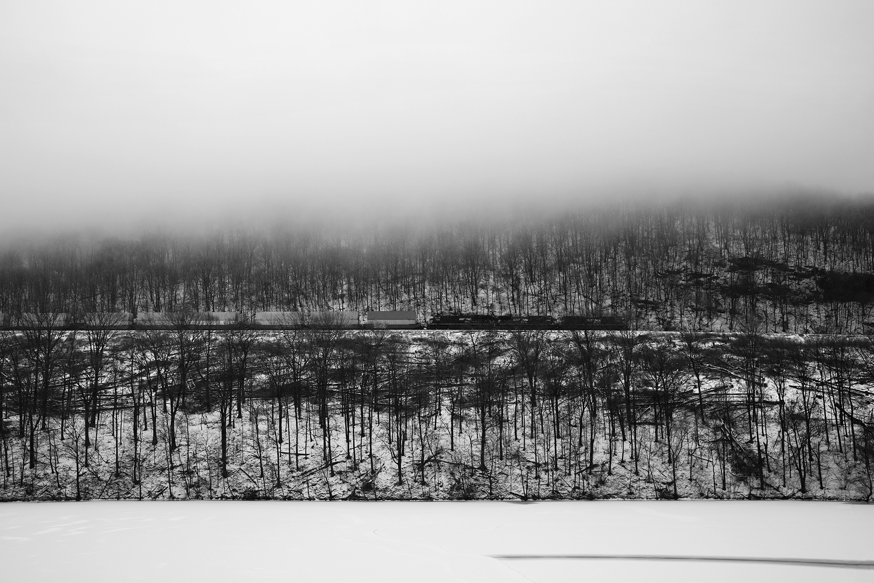 An eastbound container train descends the Allegheny mountains approaching the famed Horse Shoe Curve near Altoona, Pennsylvania. The contemporary railroad still plays a vital role in transporting the goods to stores and packages to homes around the country. Container ship lines as well as UPS, Fed Ex and trucking companies J.B. Hunt among others rely heavily on the use of the railroad to ensure merchandise makes it to the stores and packages get delivered in time for a spot under the Christmas Tree.