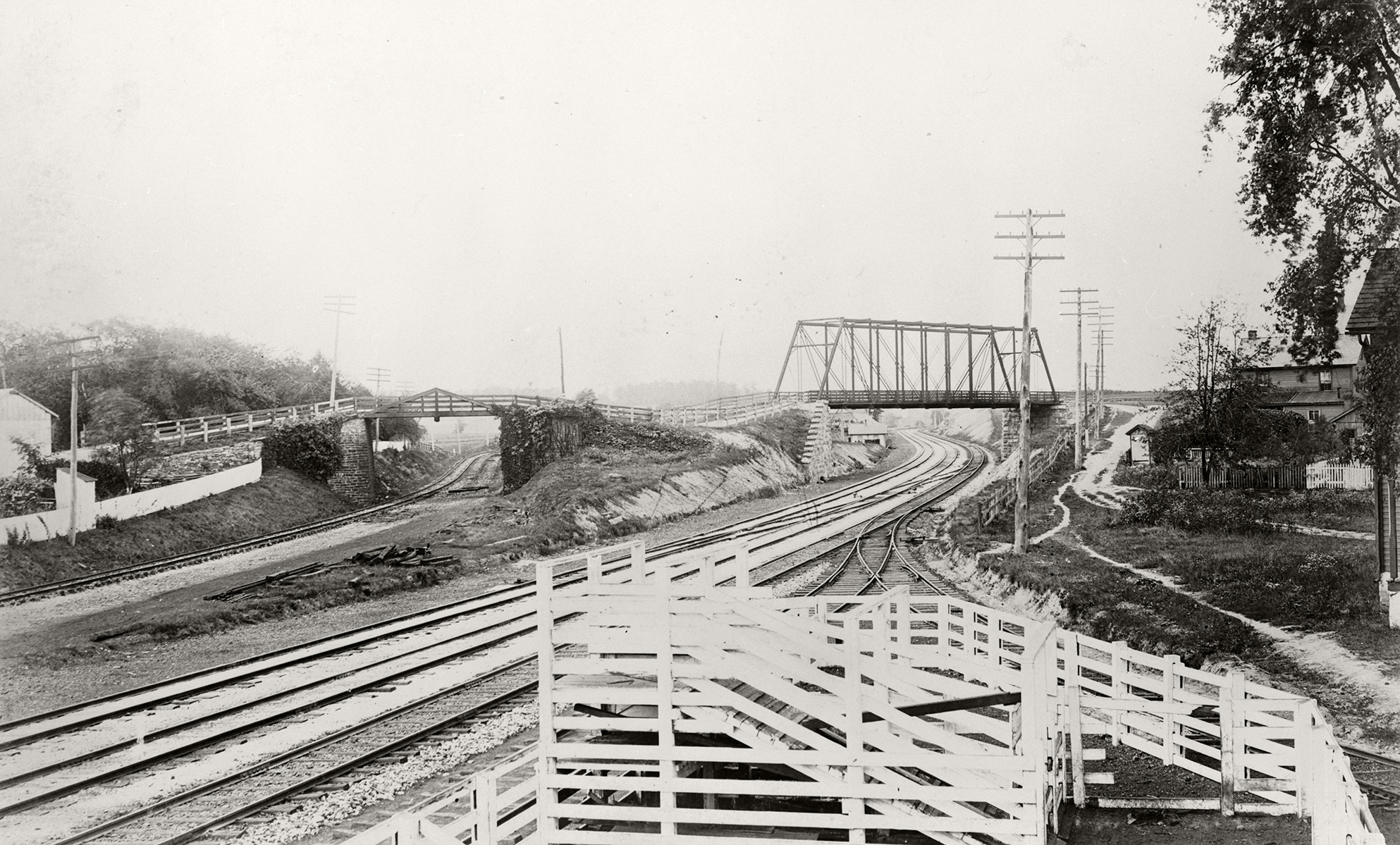 View looking west from the mainline, showing the old (left) and new (right) alignments of the right of way. Soon the old right of way and overpass would be removed. Cattle pens and a siding in the immediate foreground are in the vicinity of the freight house which still stands today. Note the absence of the fourth track which indicates that this view was before 1895. Library of Congress HAER collection.