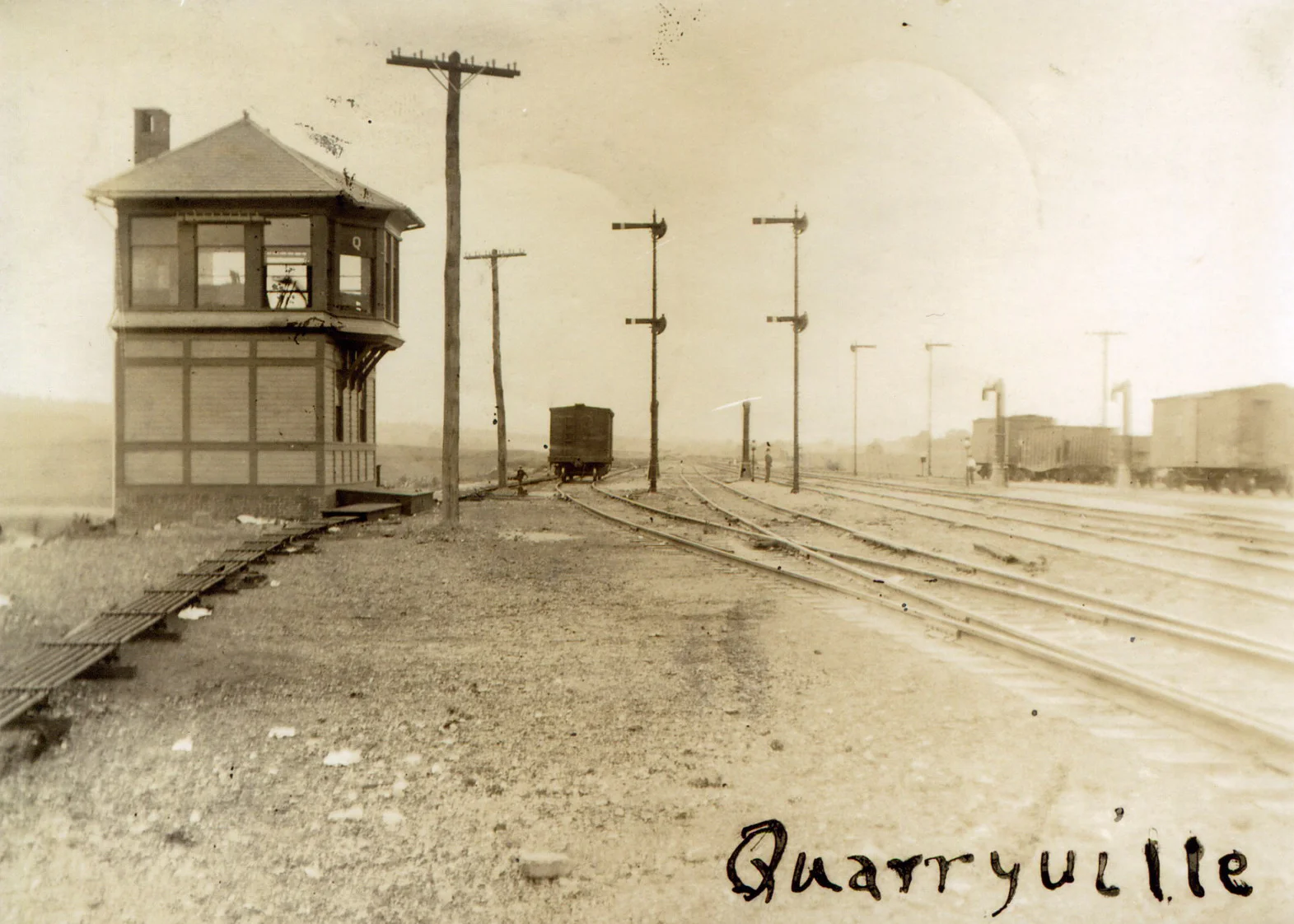 This 1906 view shows the wood frame tower at Quarryville (Milepost 10.8), the first interlocking tower west of Parkesburg. "Q" had control over the two main tracks and four additional sidings to manage helper movements assisting trains to Mars Hill Summit. Additionally, four water columns were available to top off steam locomotive tenders on their journey east or west. Image collection of William L. Seigford