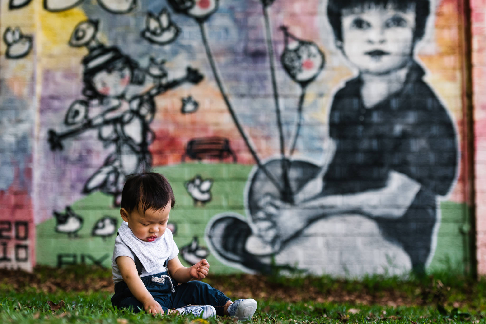 Graffiti wall behind baby boy