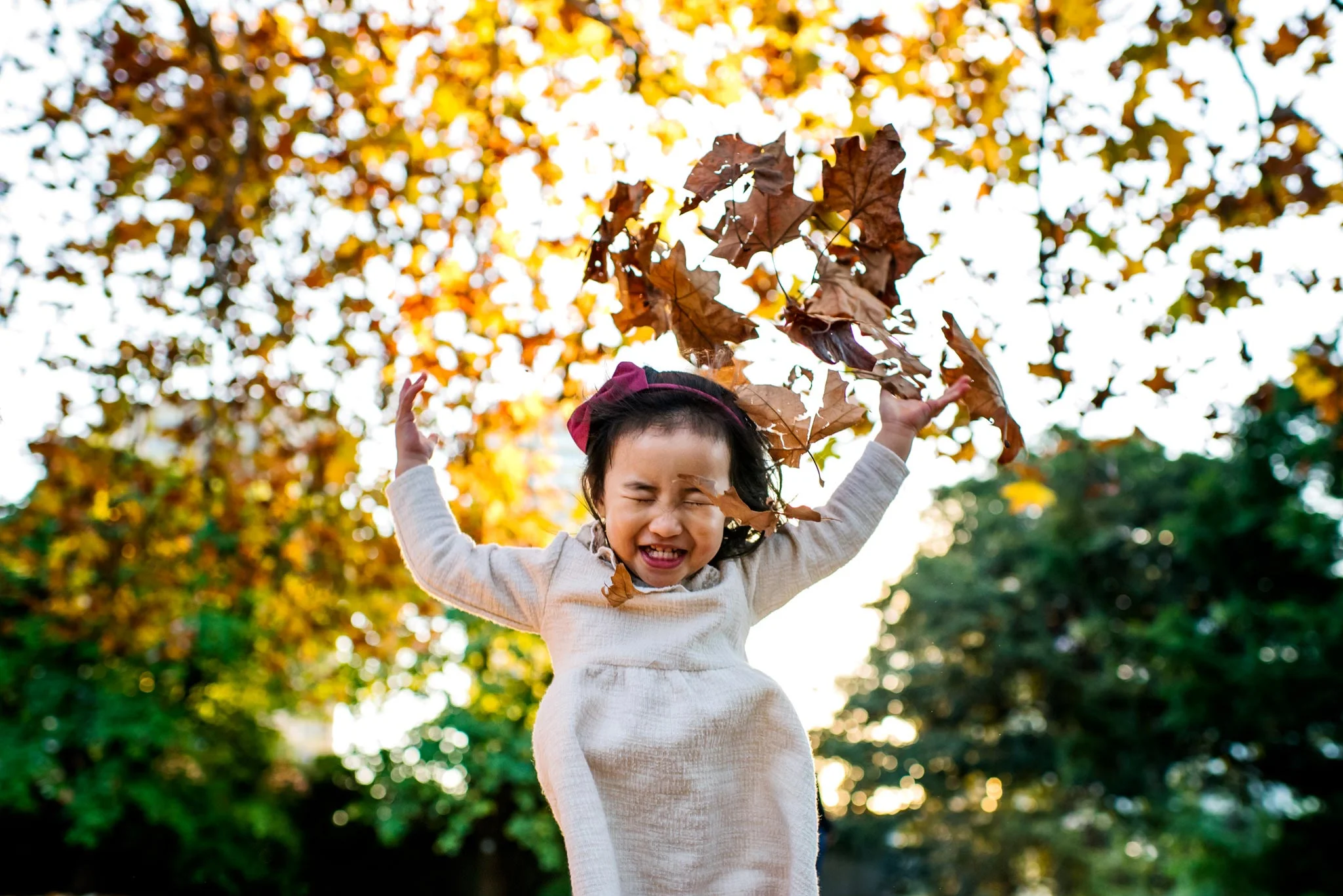 Girl playing in leaves