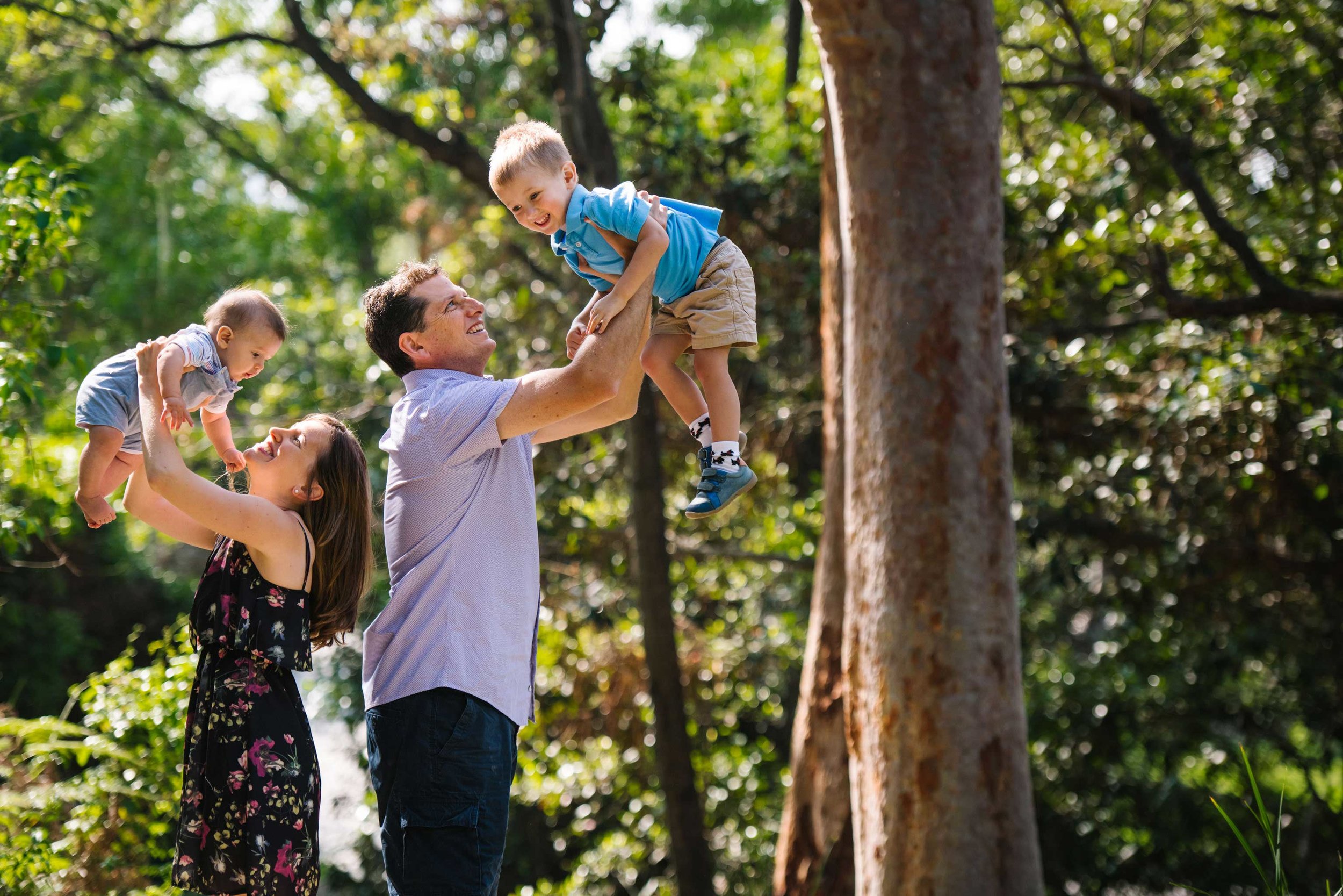 Parents hold their boys up in the air during family photo session