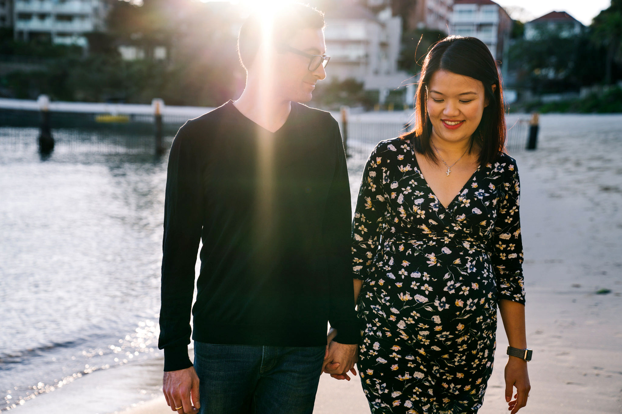 Couple walking up Little Manly Beach during maternity session