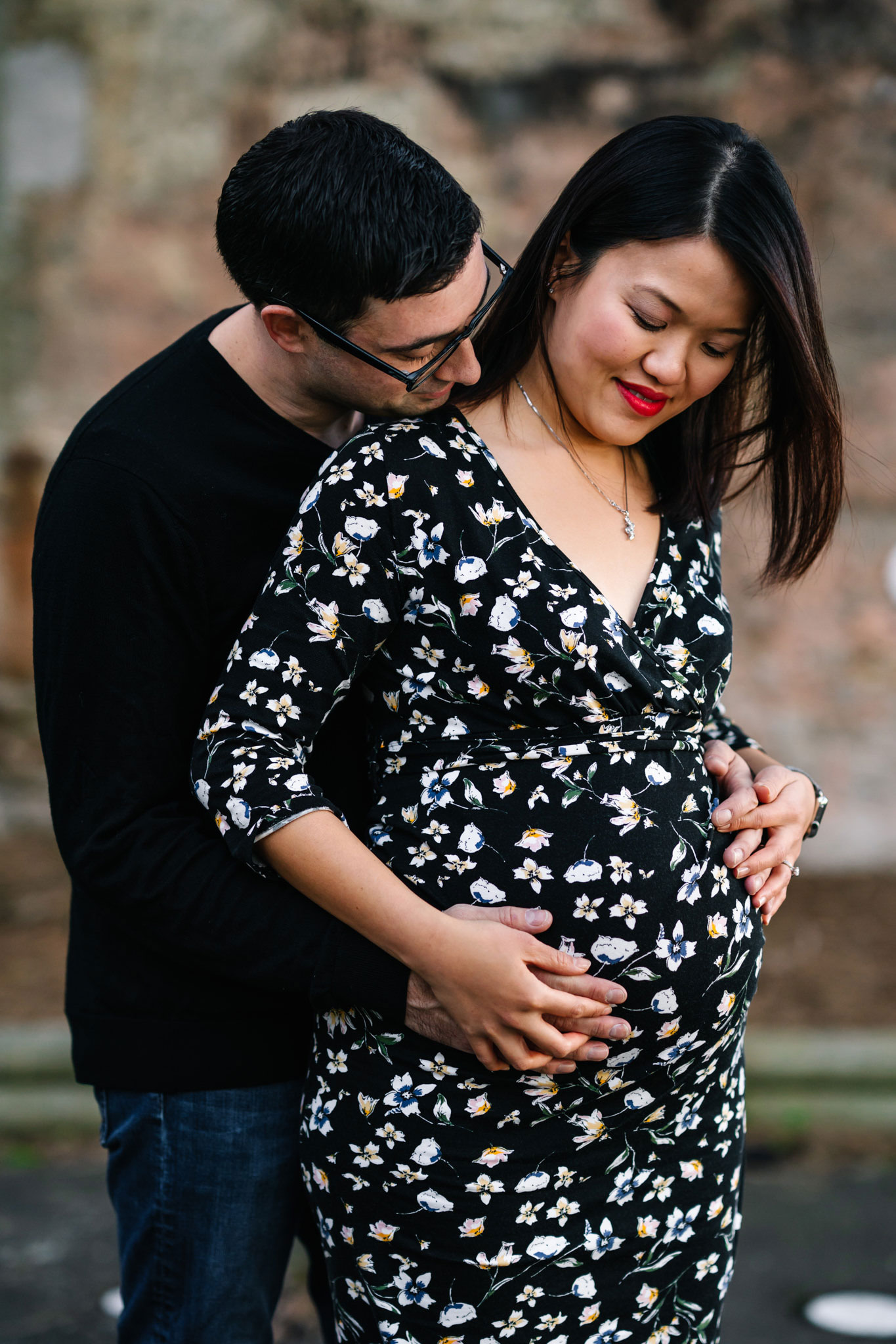 Husband hugging wife and touching her pregnant belly