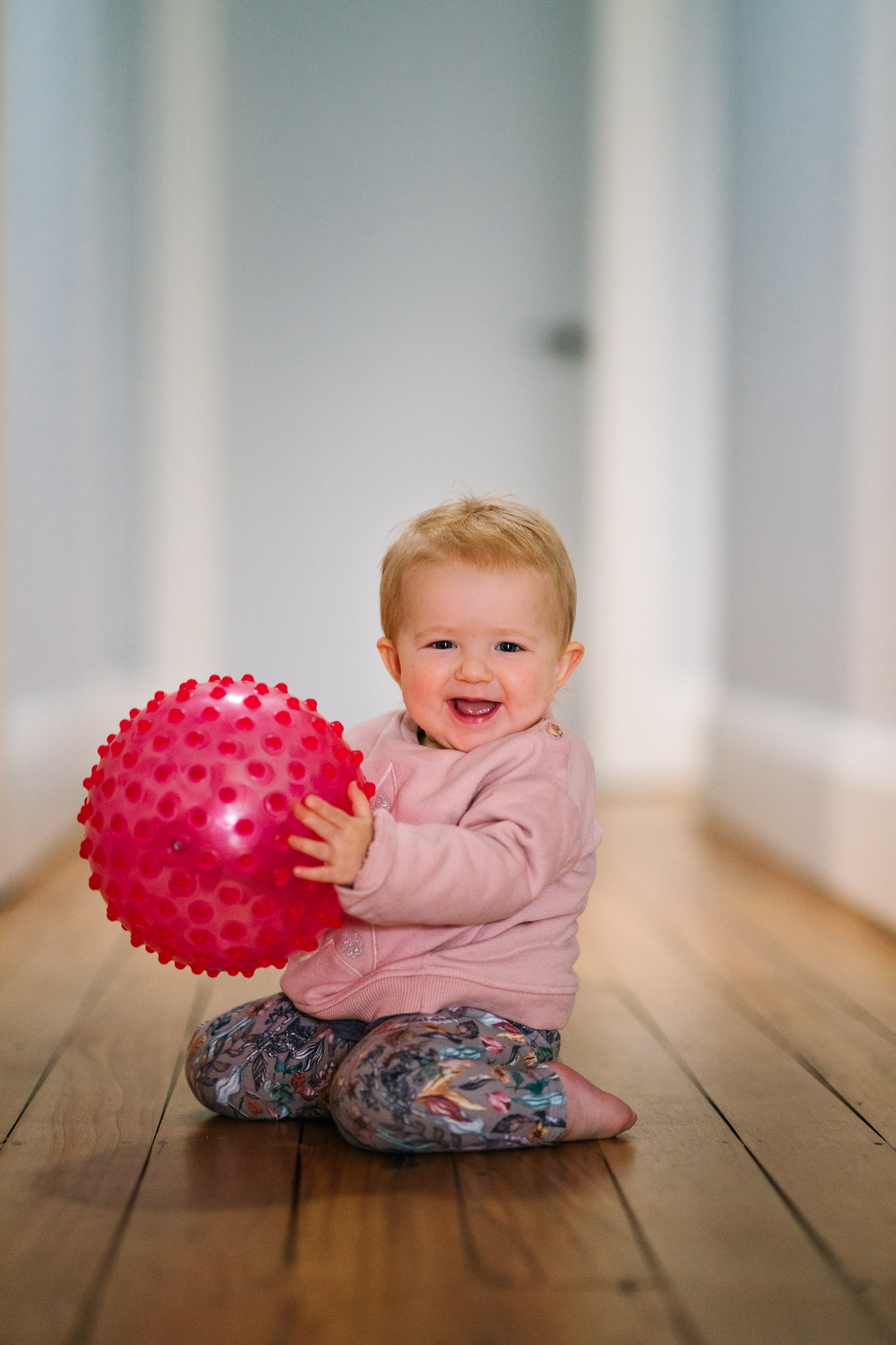 Baby playing with pink ball in period home in Coogee, NSW