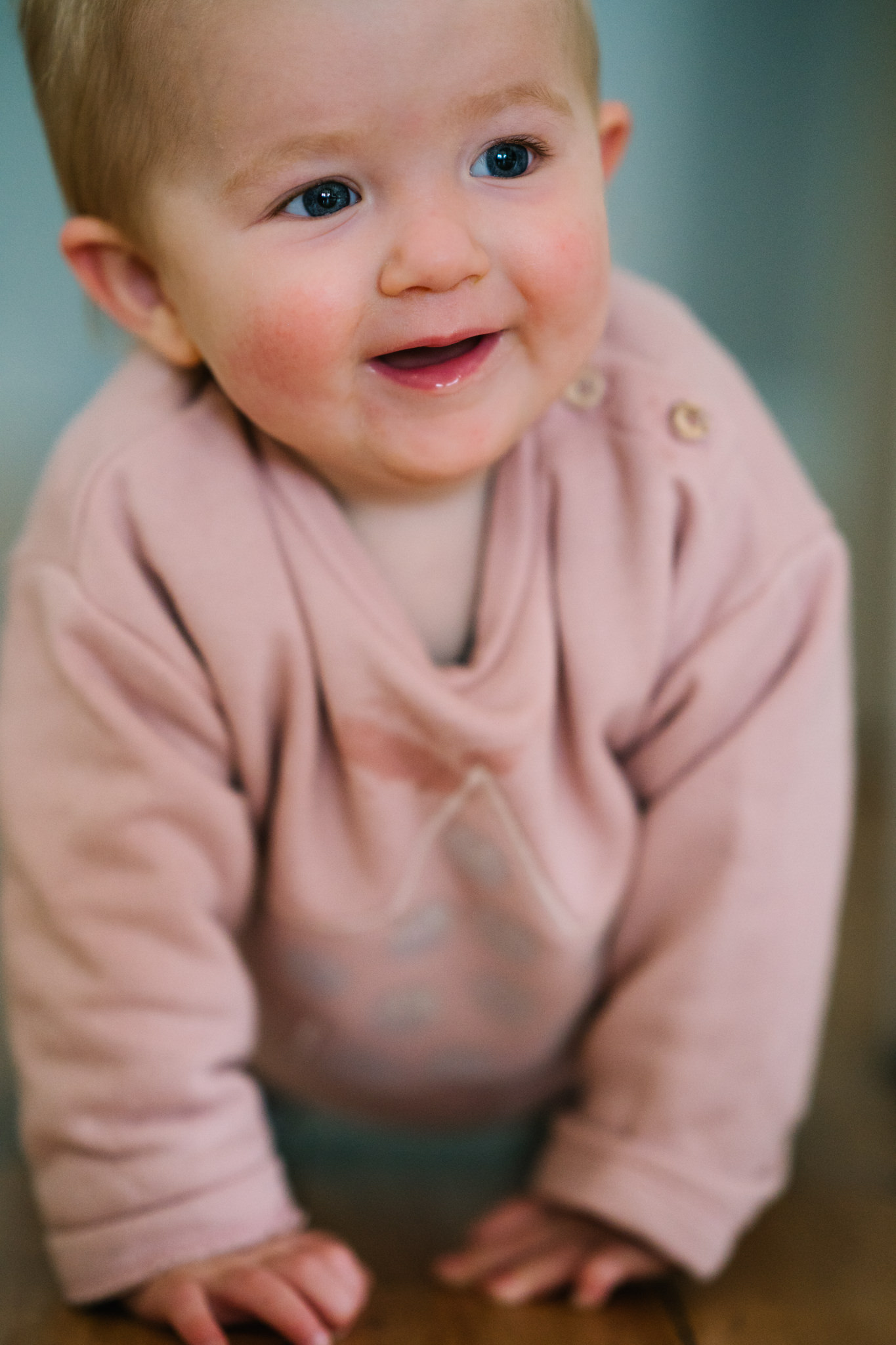 Baby smiling as she crawls towards camera