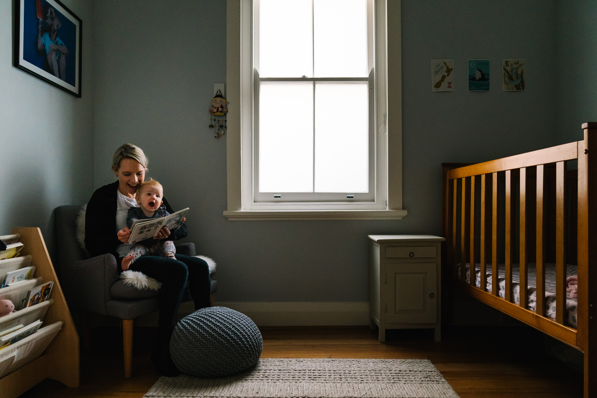 Mum and baby reading a book in a pretty nursery