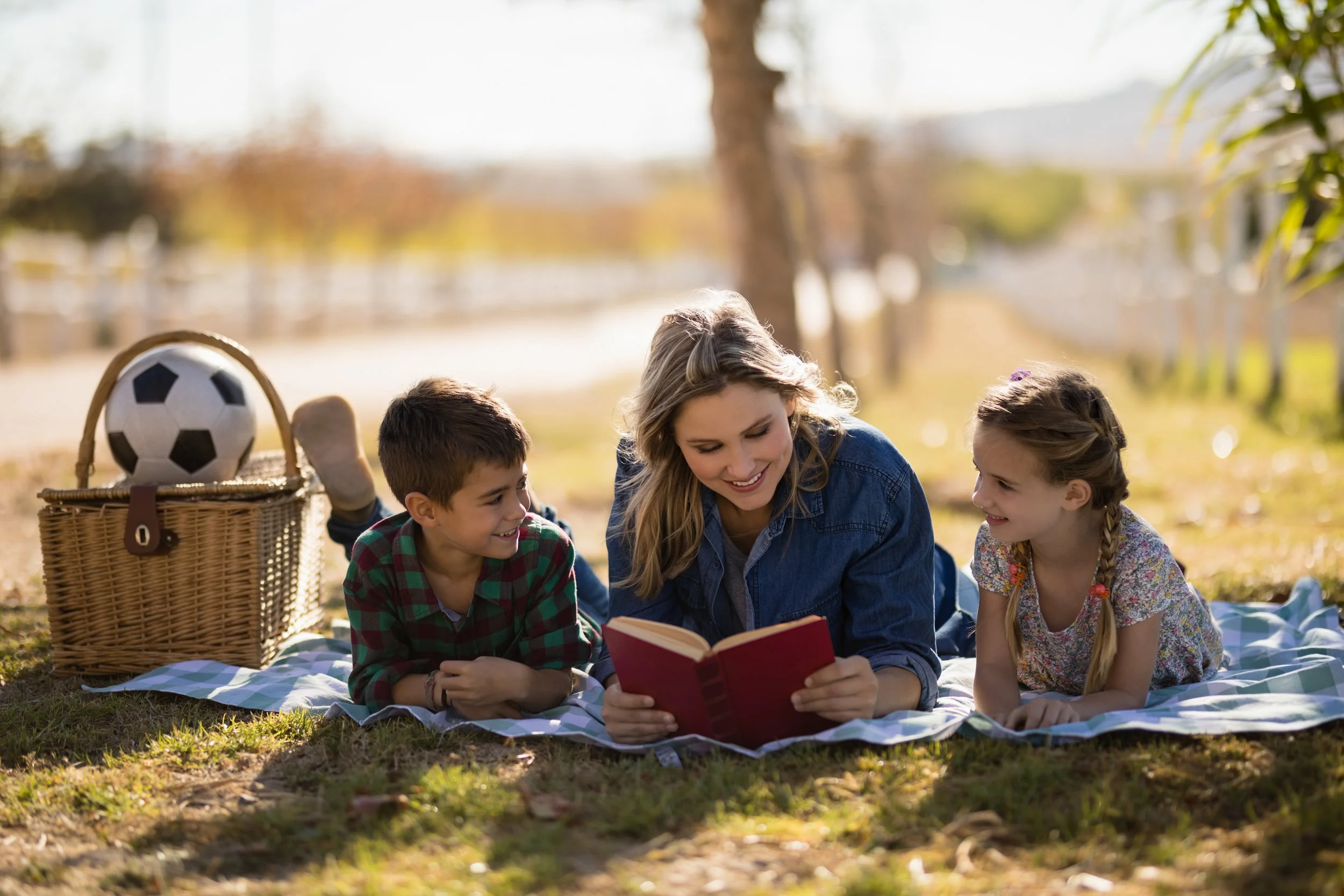 mother-and-kids-reading-novel-in-park-7CRSNZW.jpg