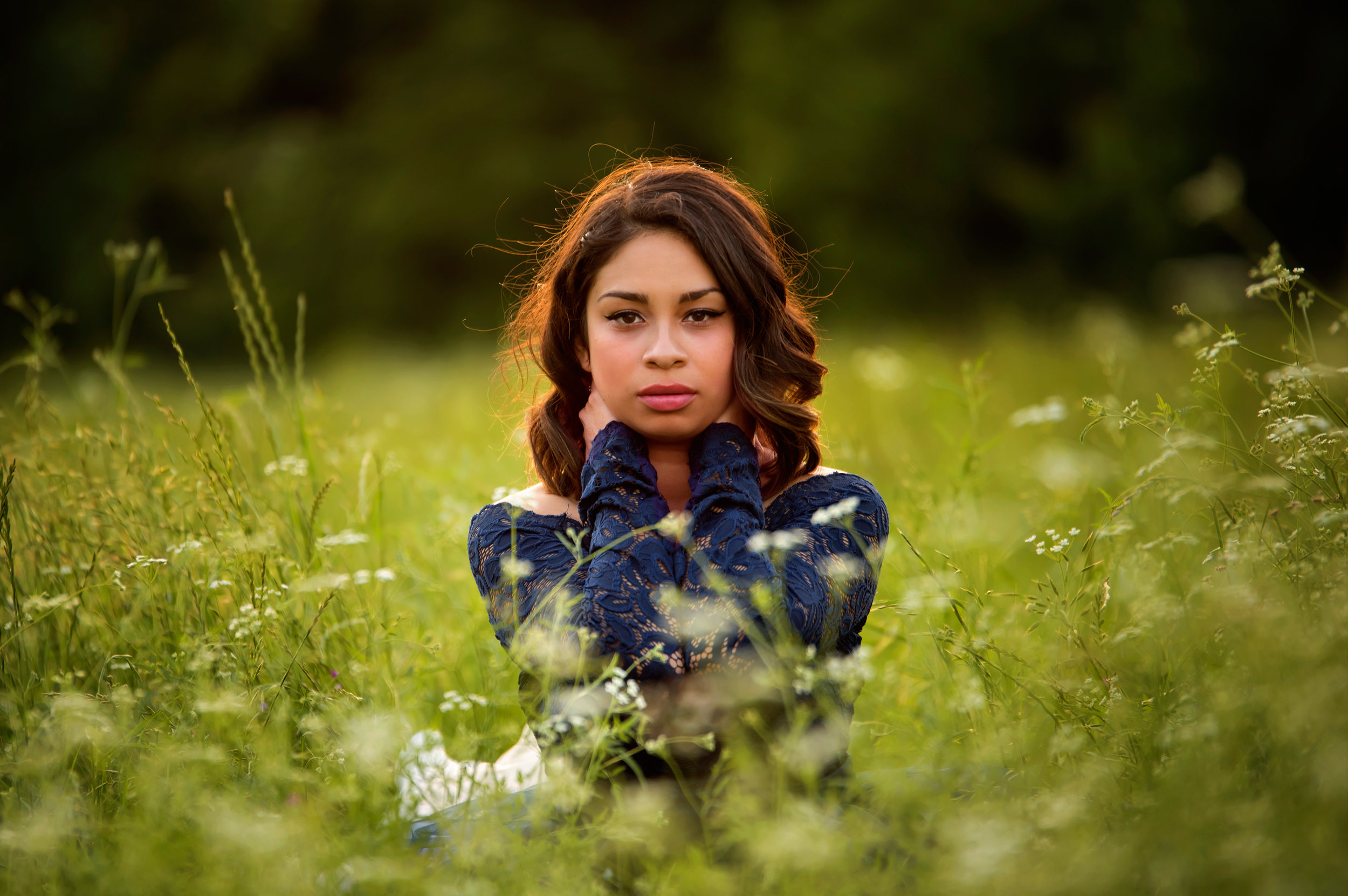  Senior portrait, girls in field of high grass wearing a jean jacket. 