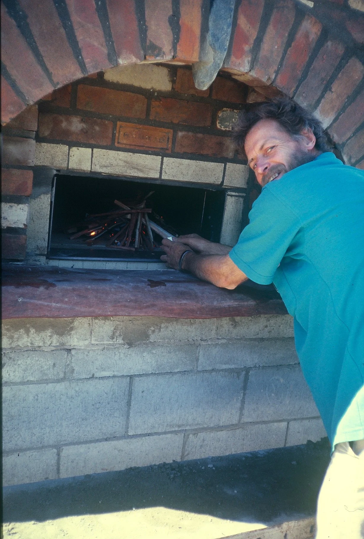 Les Bartlet lighting the first fire in his oven