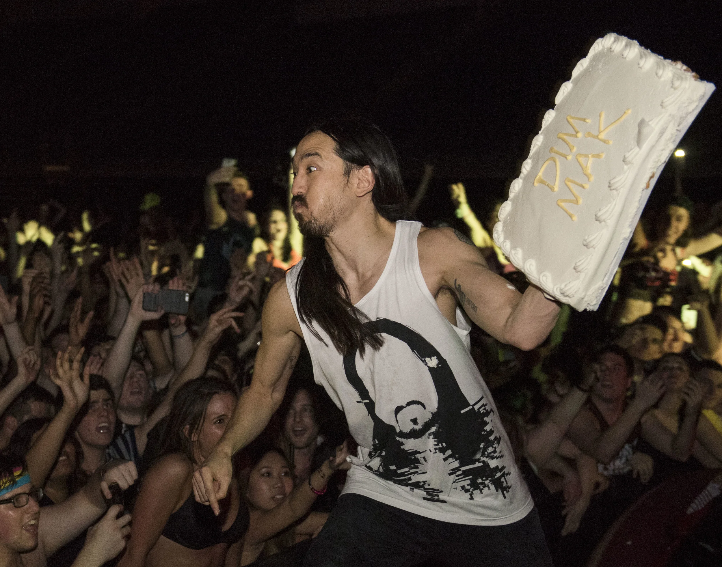 Steve Aoki throws a cake in to the crowd as part of his performance held at the Bryce Jordan Center in University Park, Pa. on Friday, April 10, 2015.