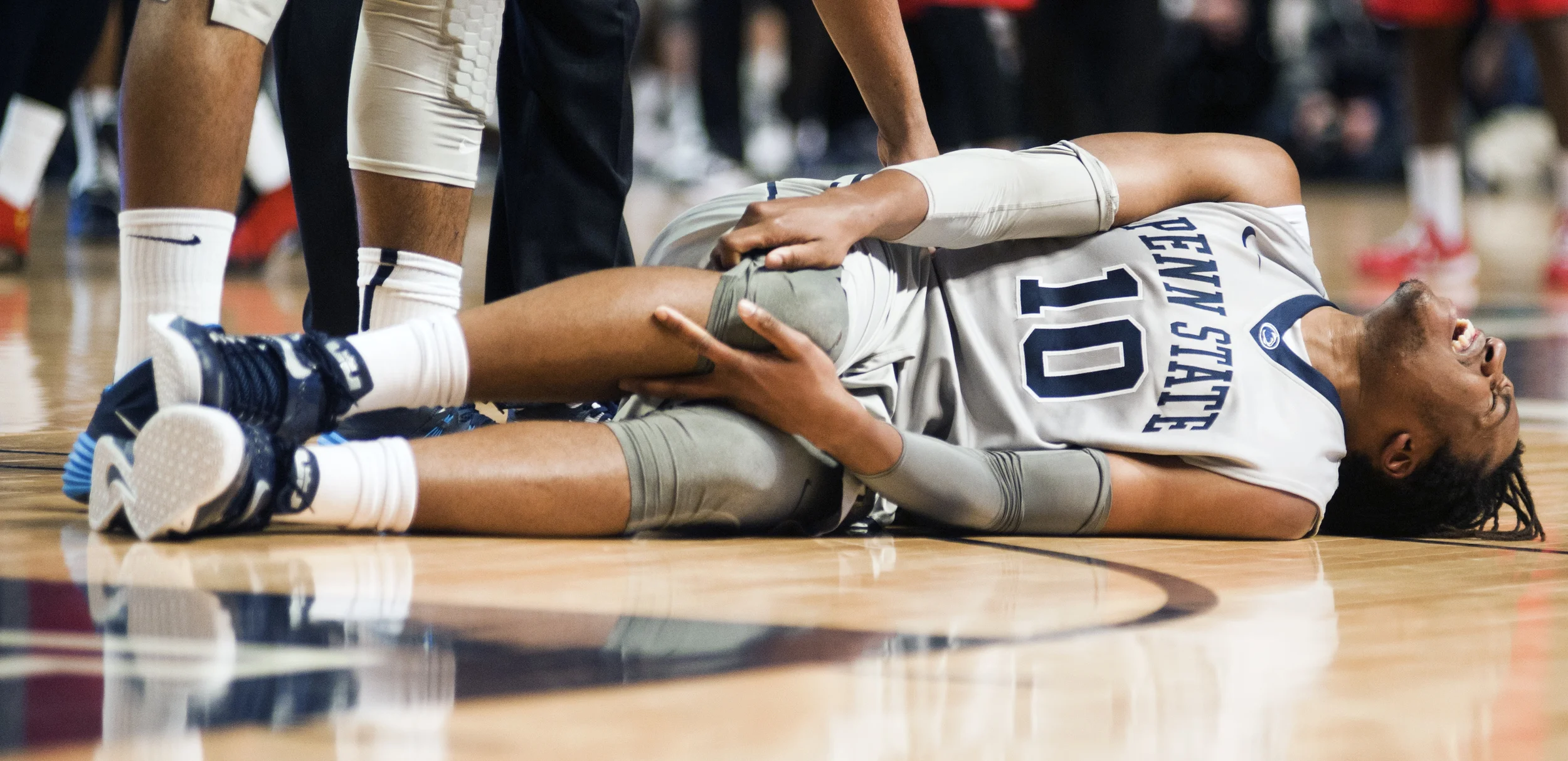 Junior forward Brandon Taylor goes down with an injury to his right knee during Penn State's game against Rutgers University on Saturday, Jan. 24, 2015.