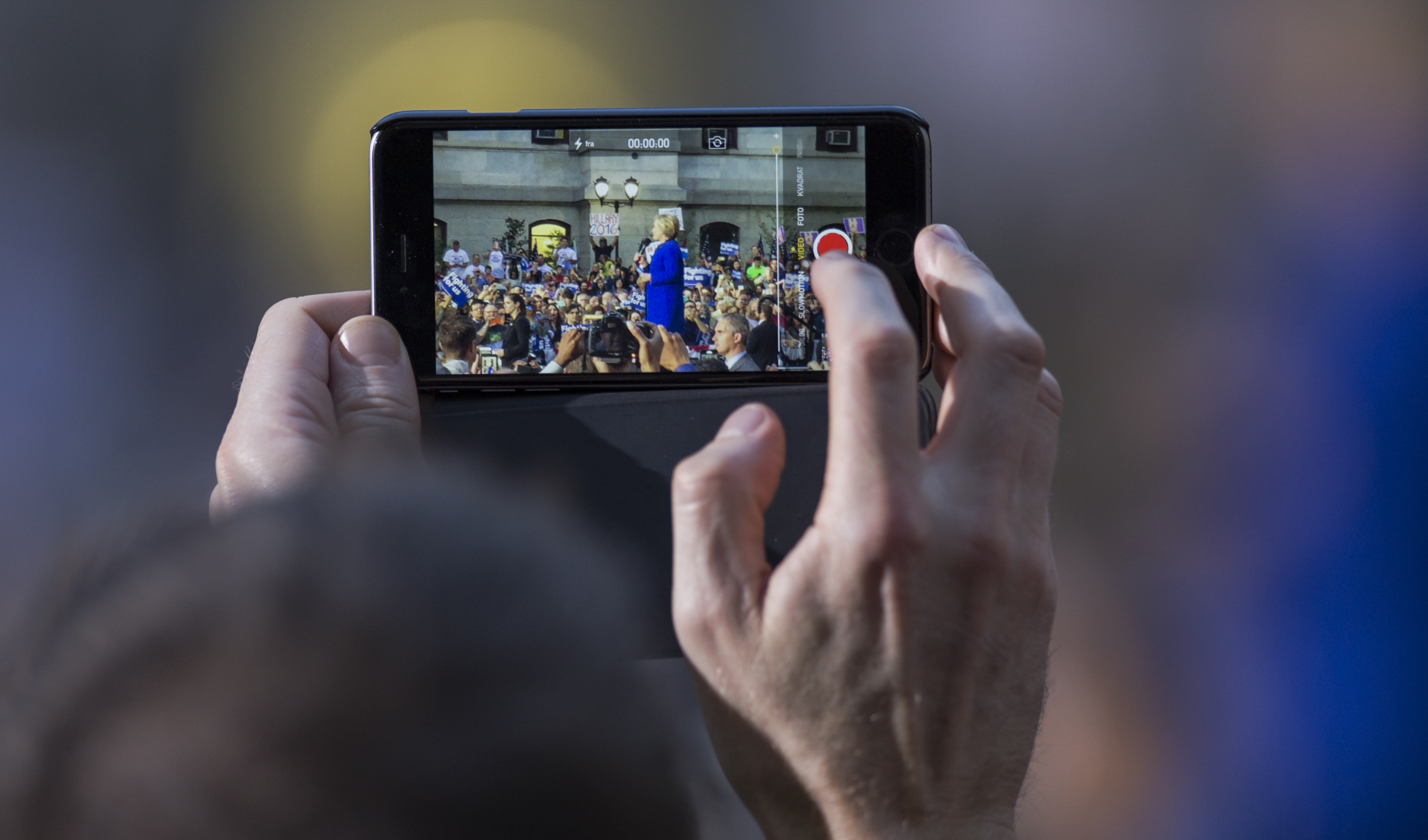 A supporter takes a video of Democratic presidential candidate Hillary Clinton on his phone as she speaks during her campaign rally held in the courtyard of City Hall in Philadelphia on Monday, April, 25, 2016.