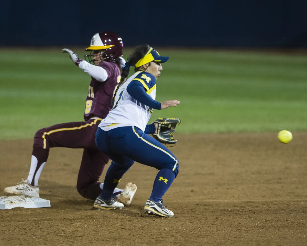 Michigan second baseman Abby Ramirez leans to catch a throw as Minnesota infielder Danielle Parlich slides safely on base during the final game of the Big Ten Tournament at Beard Field on Saturday, May 14, 2016.