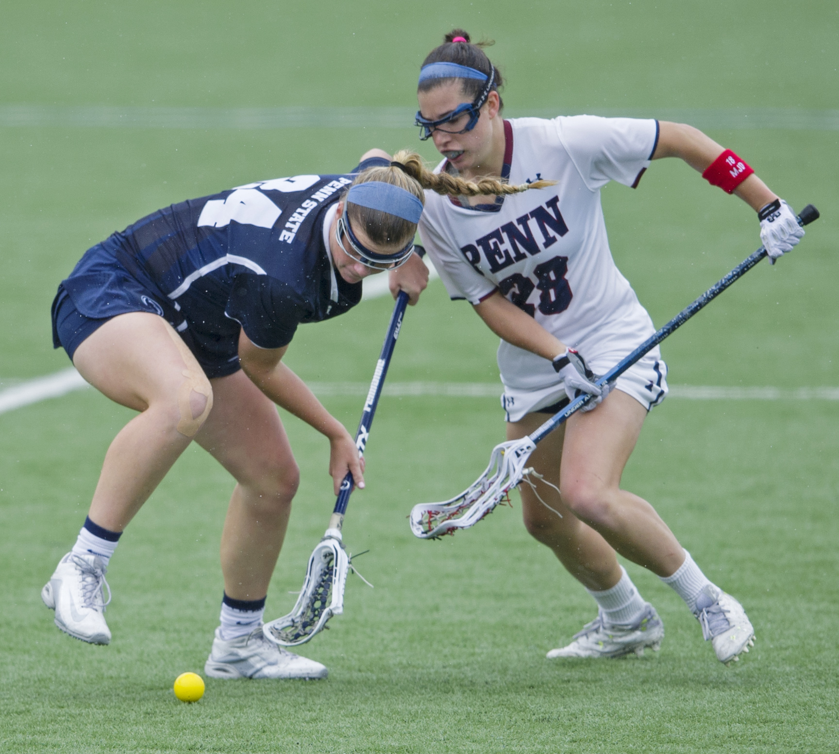 Penn State attacker Madison Carter scoops the ball under coverage from Penn mid-fielder Lely DeSimone during the NCAA quarterfinal game at the Penn State Lacrosse Stadium on Saturday, May 21, 2016.