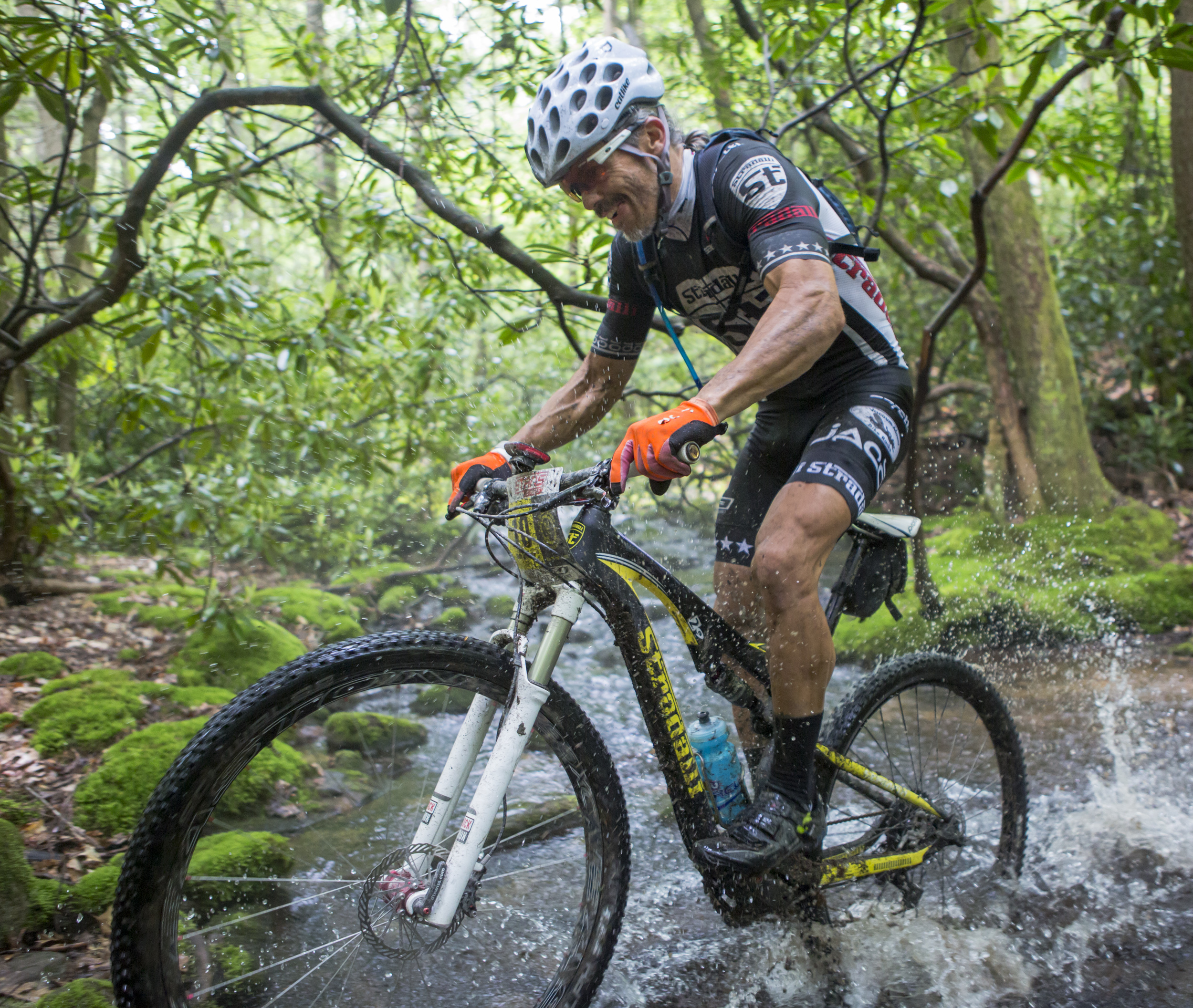 Bob McCarty of the Stradalli team powers through a stream crossing on the Lingle Valley trail during the final stage of the Tran-Sylvania Epic Mountain Bike Ride in Rothrock State Forest on Friday, June 3, 2016.