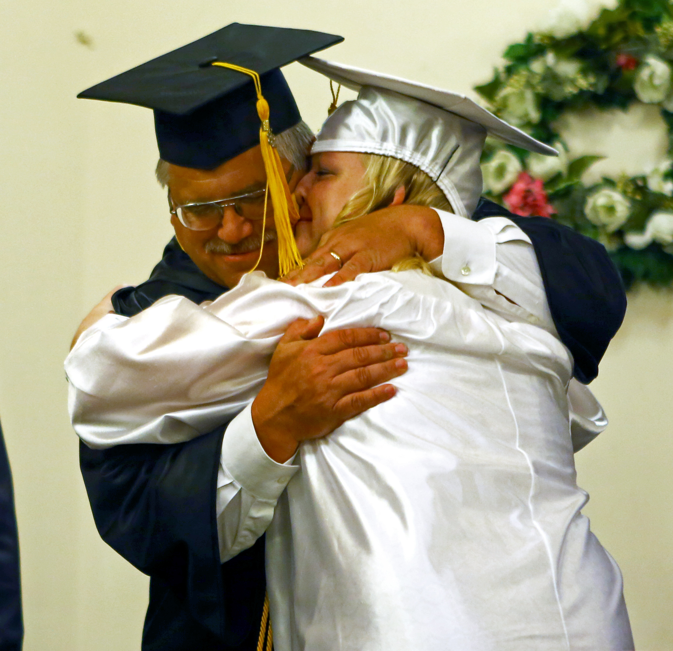 Centre County Christian Academy graduating senior Abby Maholic embraces her father and faculty member Robert Maholic after receiving her diploma during the commencement ceremony at Calvary Bible Church in Centre Hall on Friday, June 10, 2016.