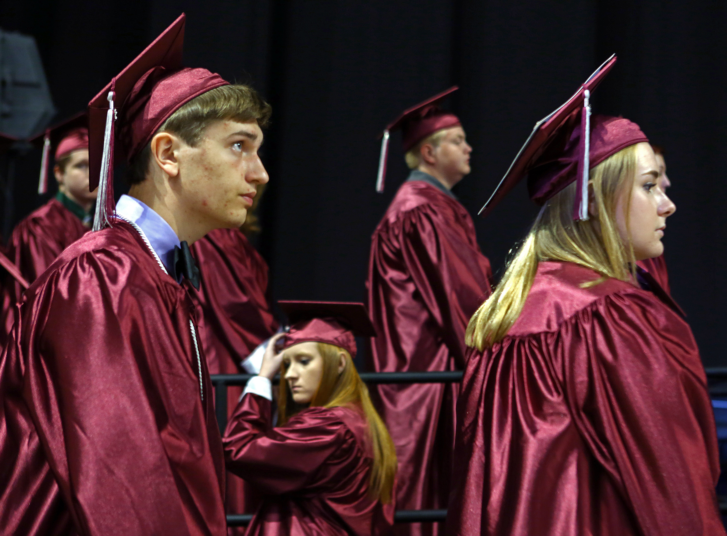 Jonathan Falk, left, and Jennie Ewton, right, wait in line with other State College Area High School graduates for their names to be called during the commencement ceremony at the Bryce Jordan Center on Saturday, June 11, 2016.