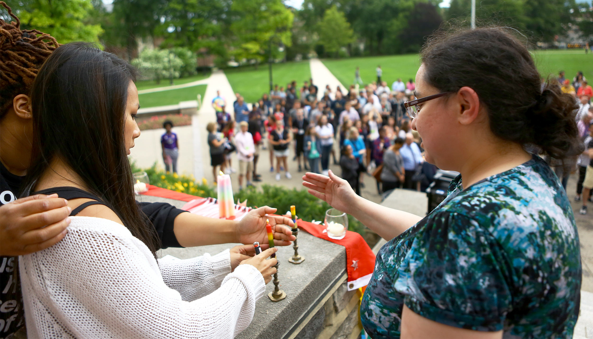 Lianne Luu, left, and Lia Talmas light candles on the steps of Old Main to start the candle light vigil honoring the victims of the Orlando, Florida shooting victims on Monday, June 13, 2016.