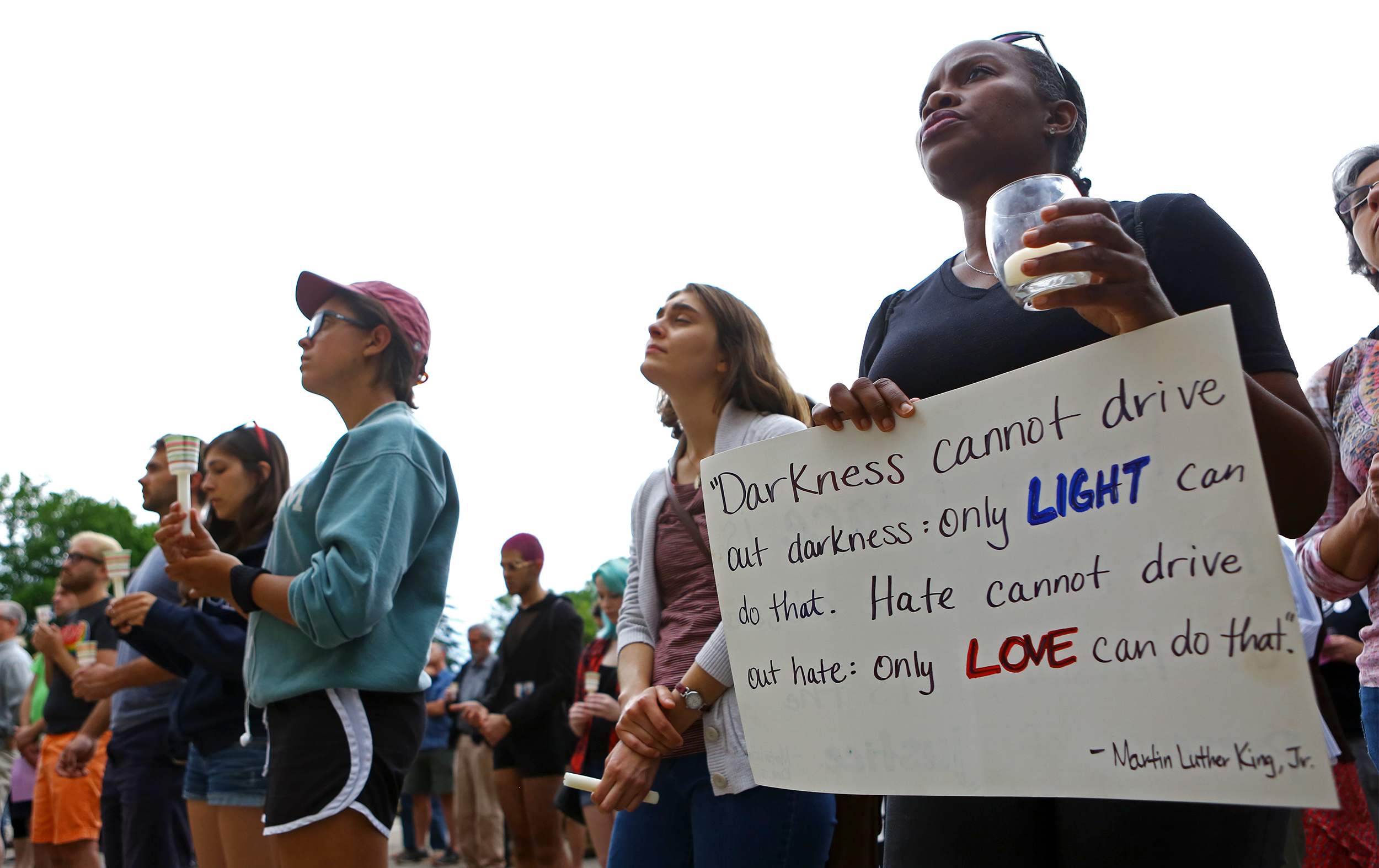 Penn State assistant professor in African American studies Dr. AnneMarie Mingo holds a sign quoting Dr. Martin Luther King Jr. on the steps of Old Main during the candle light vigil honoring the Orlando, Florida shooting victims on Monday, June 13, 2016. 