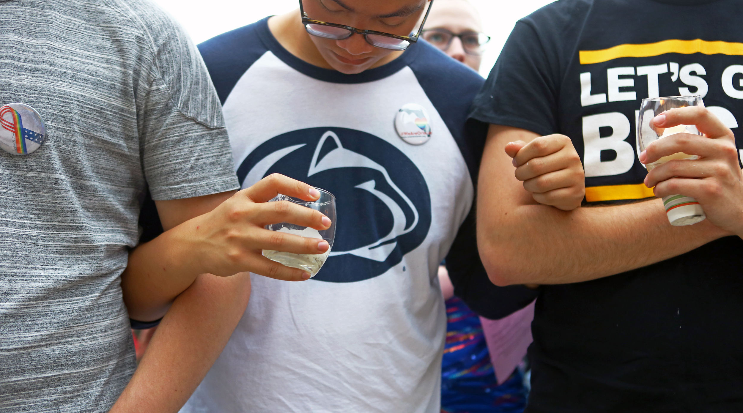 Penn State students and State College community members join arms in a moment of silence during the candle light vigil honoring the victims of the Orlando, Florida shooting victims on the steps of Old Main on Monday, June 13, 2016. 
