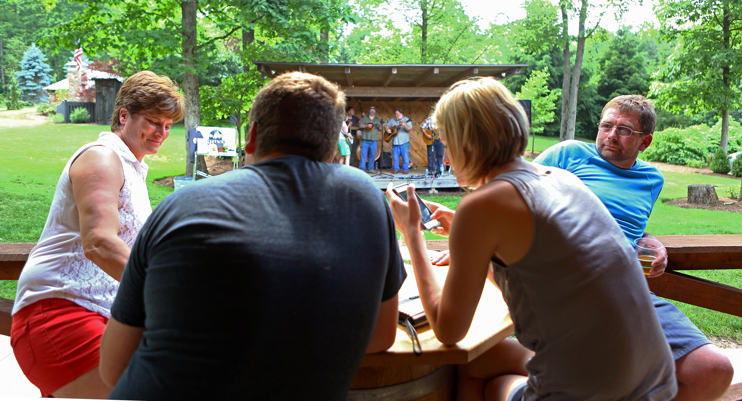 Matt Carney (far right) sits with his family as the Tussey Mountain Moonshiners perform during the Father's Day barbecue at Seven Mountains Wine Cellars on Sunday, June 19, 2016.