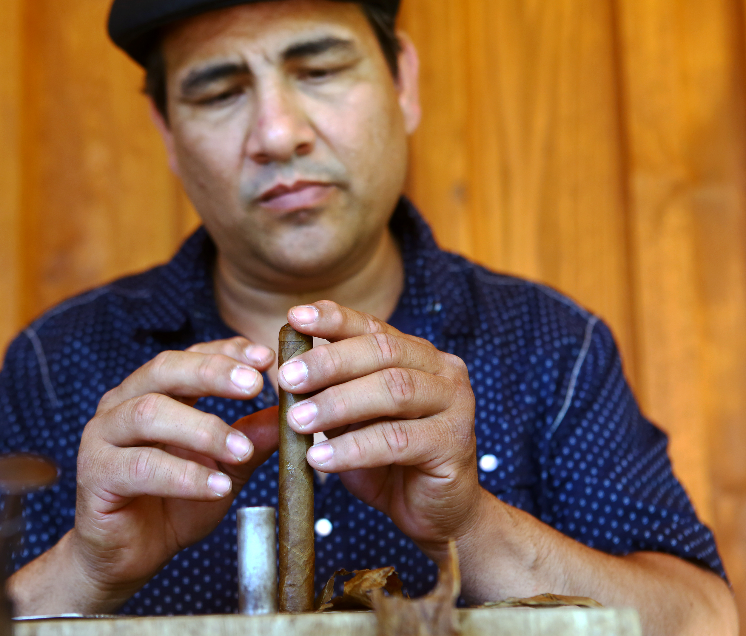 Master cigar roller Juan Carlos originally of Havanna, Cuba puts the finishing touches on the end of a cigar during the Father's Day barbecue hosted by Seven Mountains Wine Cellars on Sunday, June 19, 2016.