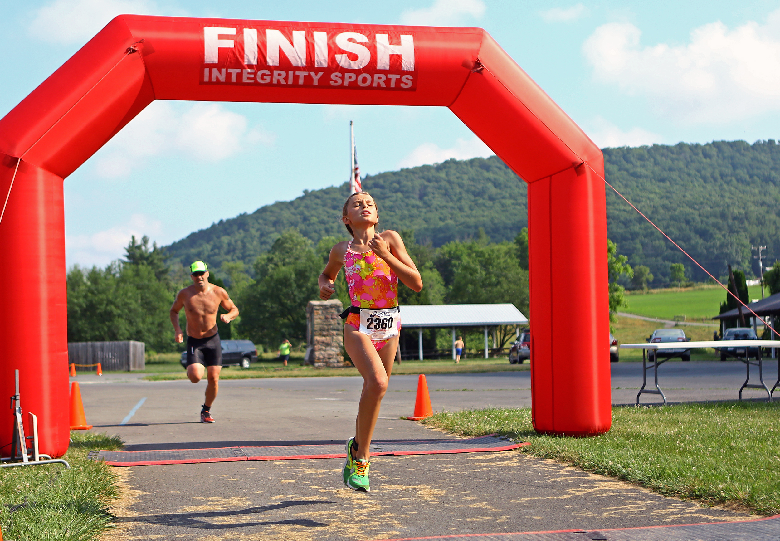 Marlee Kwasnica of State College crosses the finish line at Millheim Pool to complete the Millheim Pool Sprint Mini Triathlon with a time of 48:21 on Saturday, June 25, 2016. 
