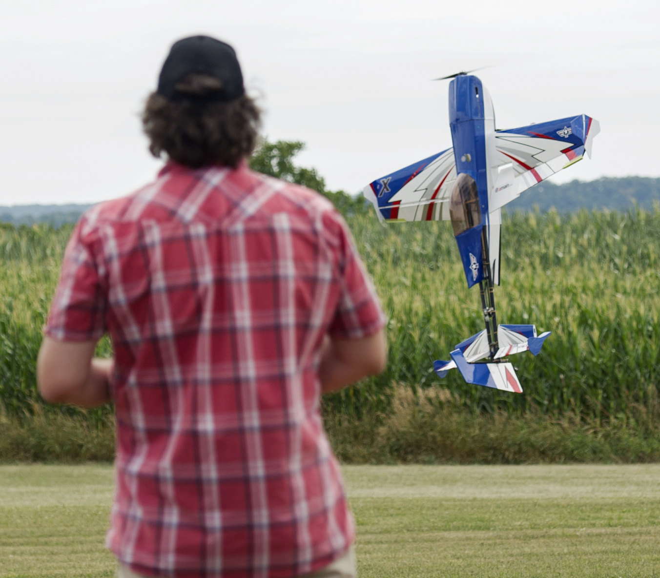 Arron Bates of West Decantur holds his custom build radio control plane, called "The Honey Badger" at a hover over the Centre Airpark's runway during the State College Radio Control Club Air Show on Sunday, July 24, 2016.