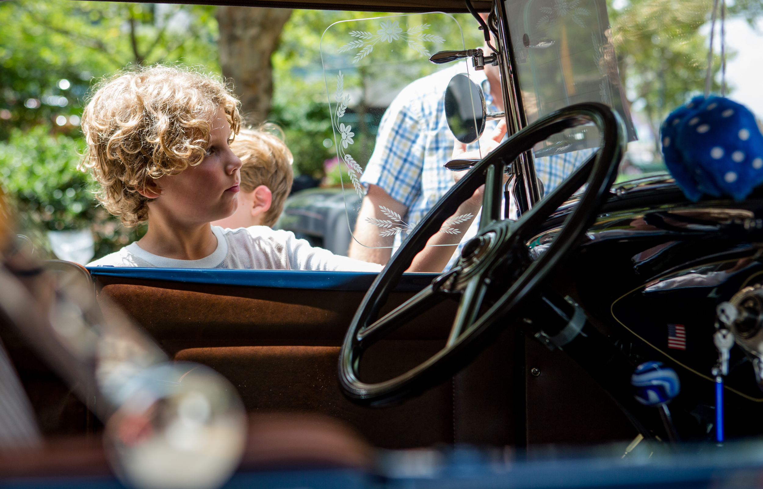 Ben Garthwaite of State College examines the side mirrors on a restored 1930 Ford Deluxe Roadster during the Last Cruise Car Show on Allen Street on Sunday, July 31, 2016