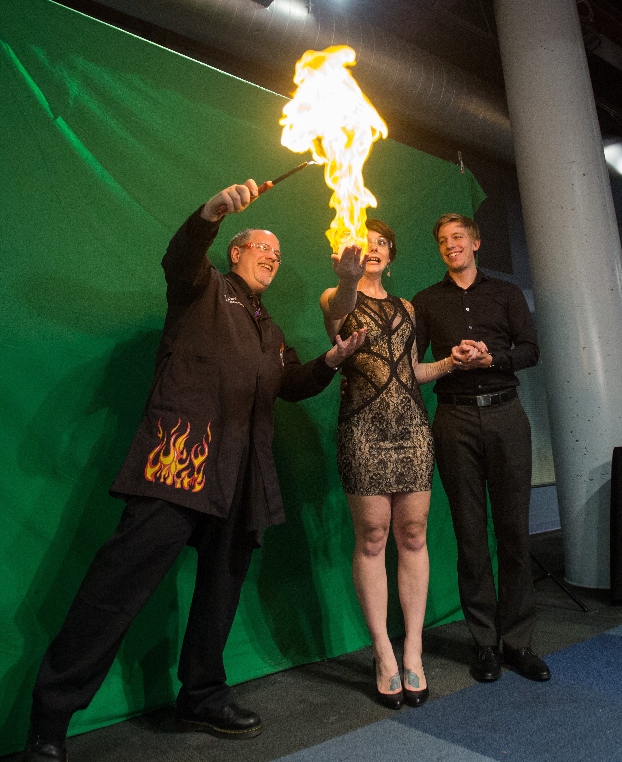 Imagination Station chief scientist Carl Nelson lights the methane filled bubbles in Bri Gibson's hand to take a photo with Ben Gibson during the Bash 7 fundraiser at Imagination Station in downtown Toledo on Saturday, Sept. 17, 2016.