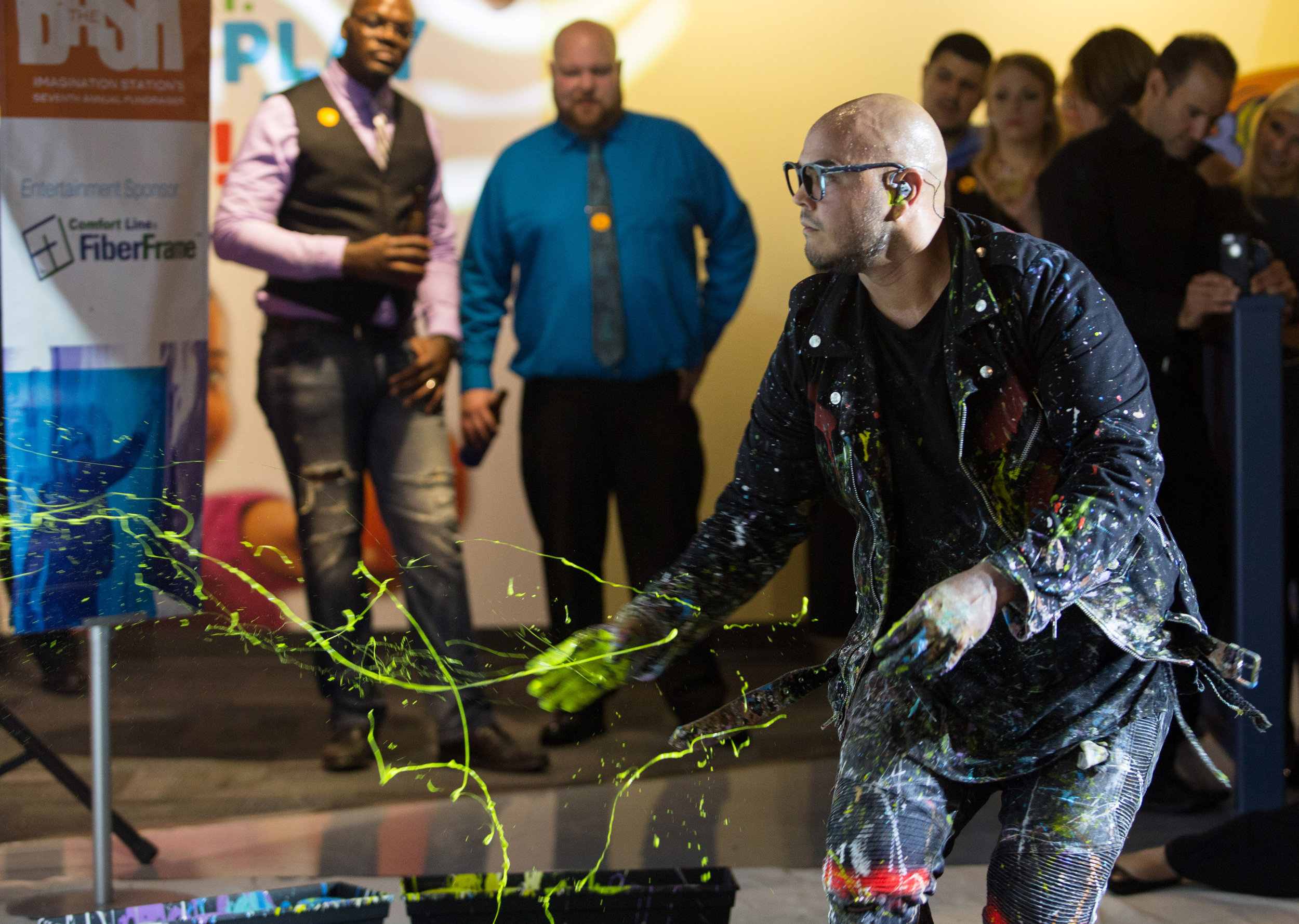 Performance painter David Garibaldi uses his hands to spray one of his paintings with droplets of paint during the Bash 7 fundraiser at Imagination Station in downtown Toledo on Saturday, Sept. 17, 2016.