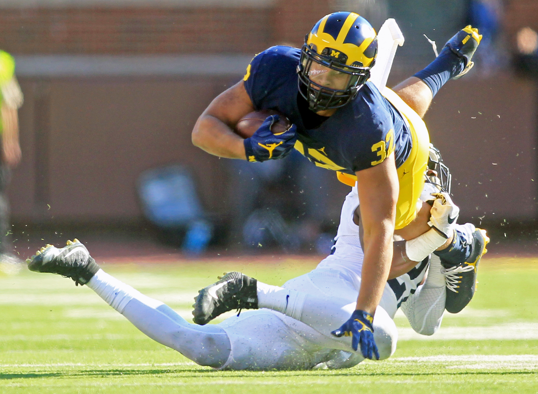 Michigan running back Ty Isaac dives after being tripped up by Penn State Amani Oruwariye during the game against Penn State at "The Big House" in Ann Arbor on Saturday, Sept. 24, 2016. Michigan won the game 49-10. 
