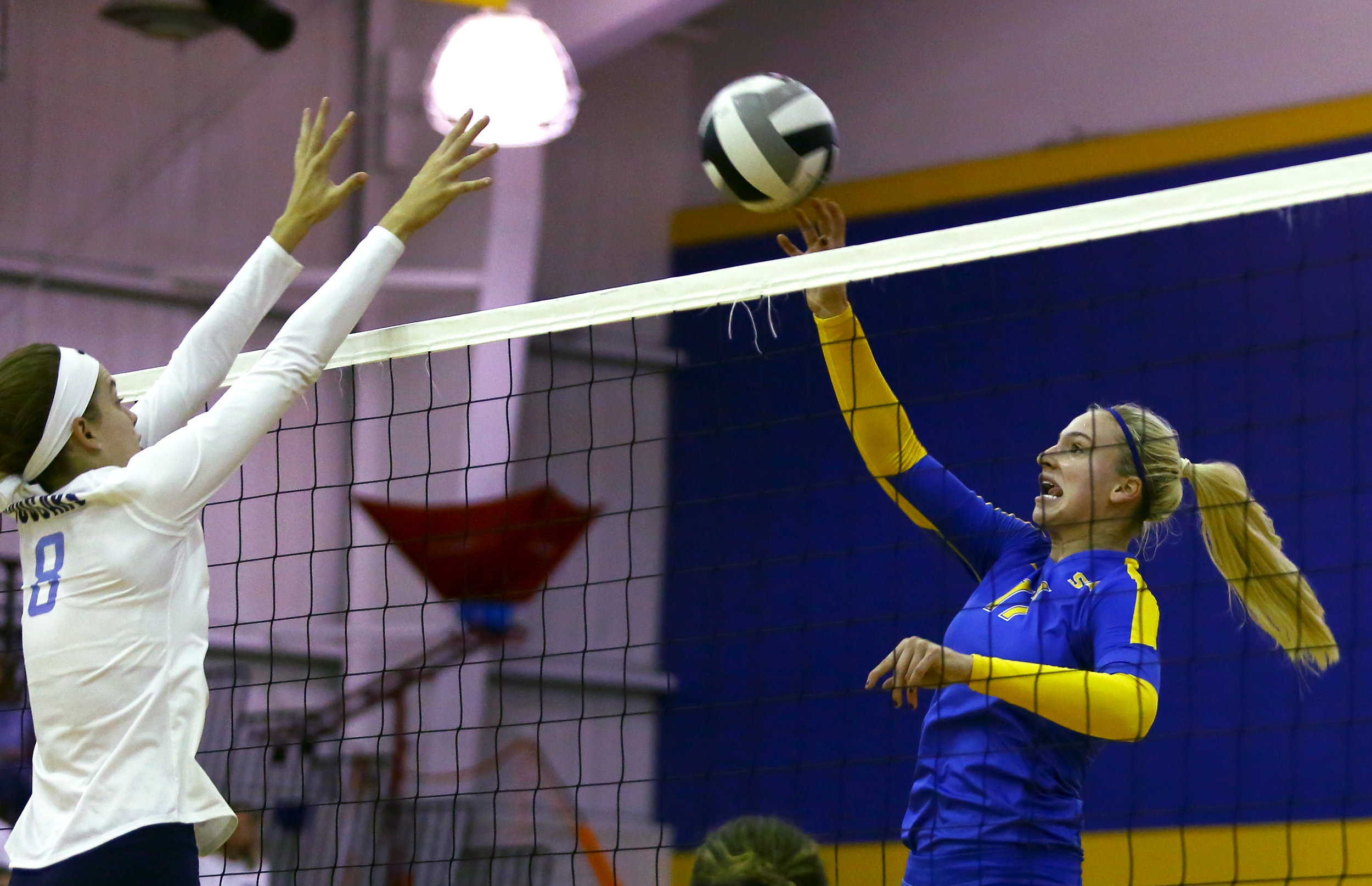 St. Ursula middle hitter Mariah Paulette jumps for a spike as Mount Notre Dame high school middle blocker Sarah Riesenberger attempts to block during the volleyball match at St. Ursula Academy on Saturday, October 1, 2016. St. Ursula won the match 3 sets to 1. 